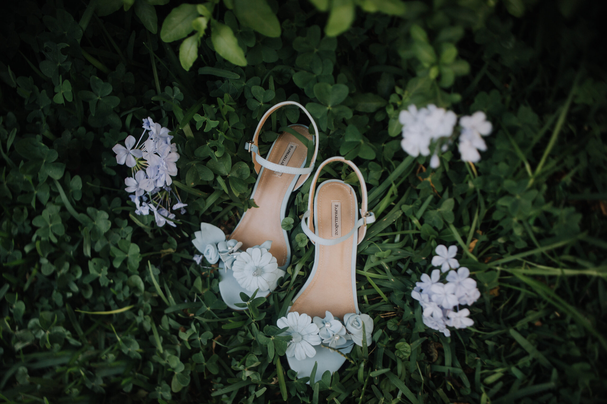 brides wedding heels sit in the grass