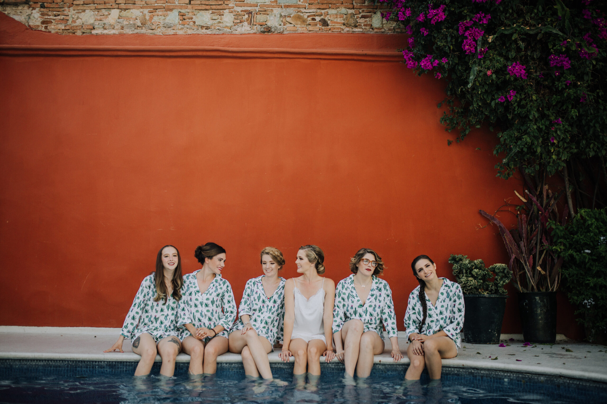 bridesmaids sit with their feet in the water before they prepare for the wedding day