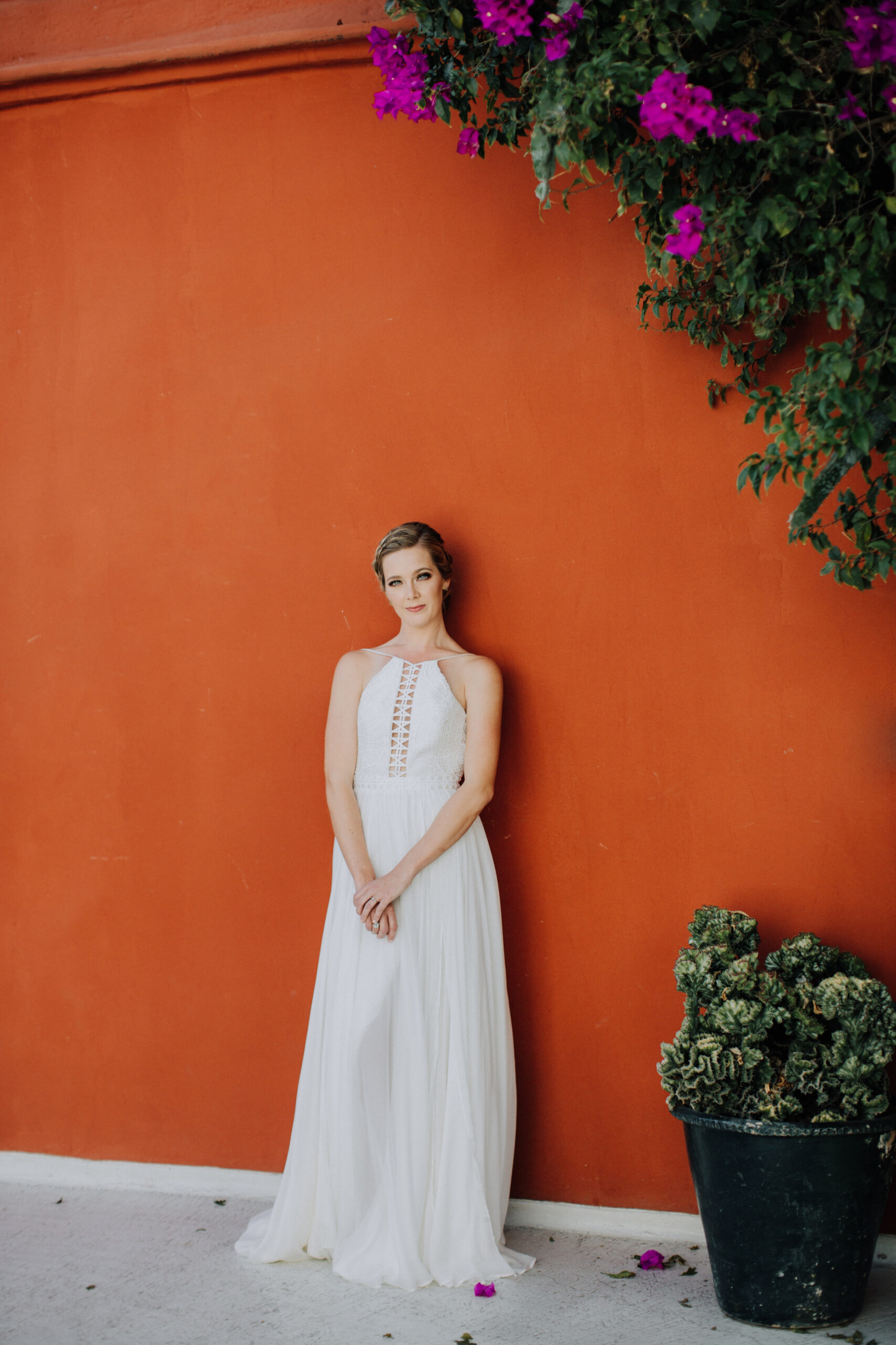 bride stands against a striking orange wall before her Oaxaca wedding day