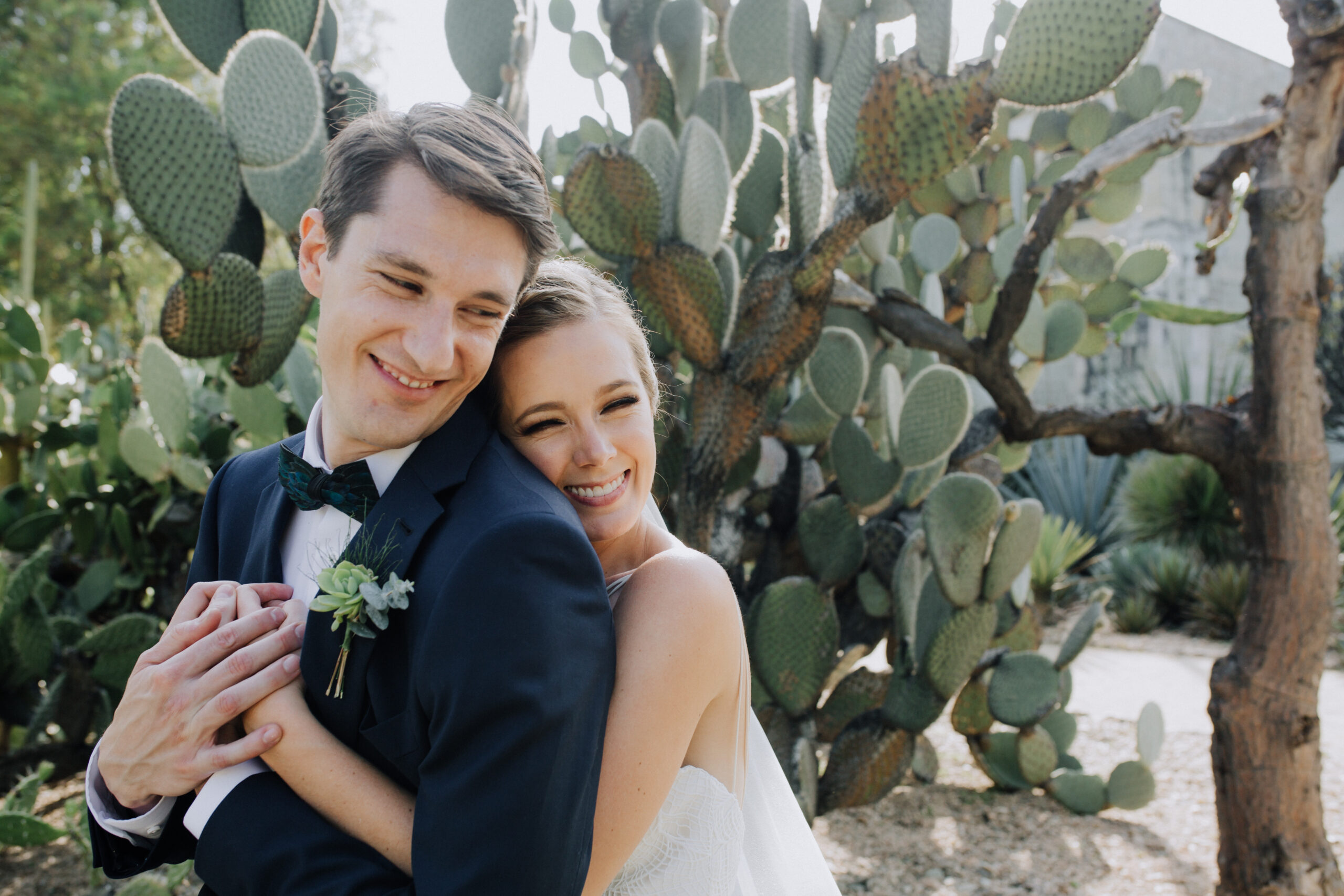stunning bride and groom pose in front of the cactus garden
