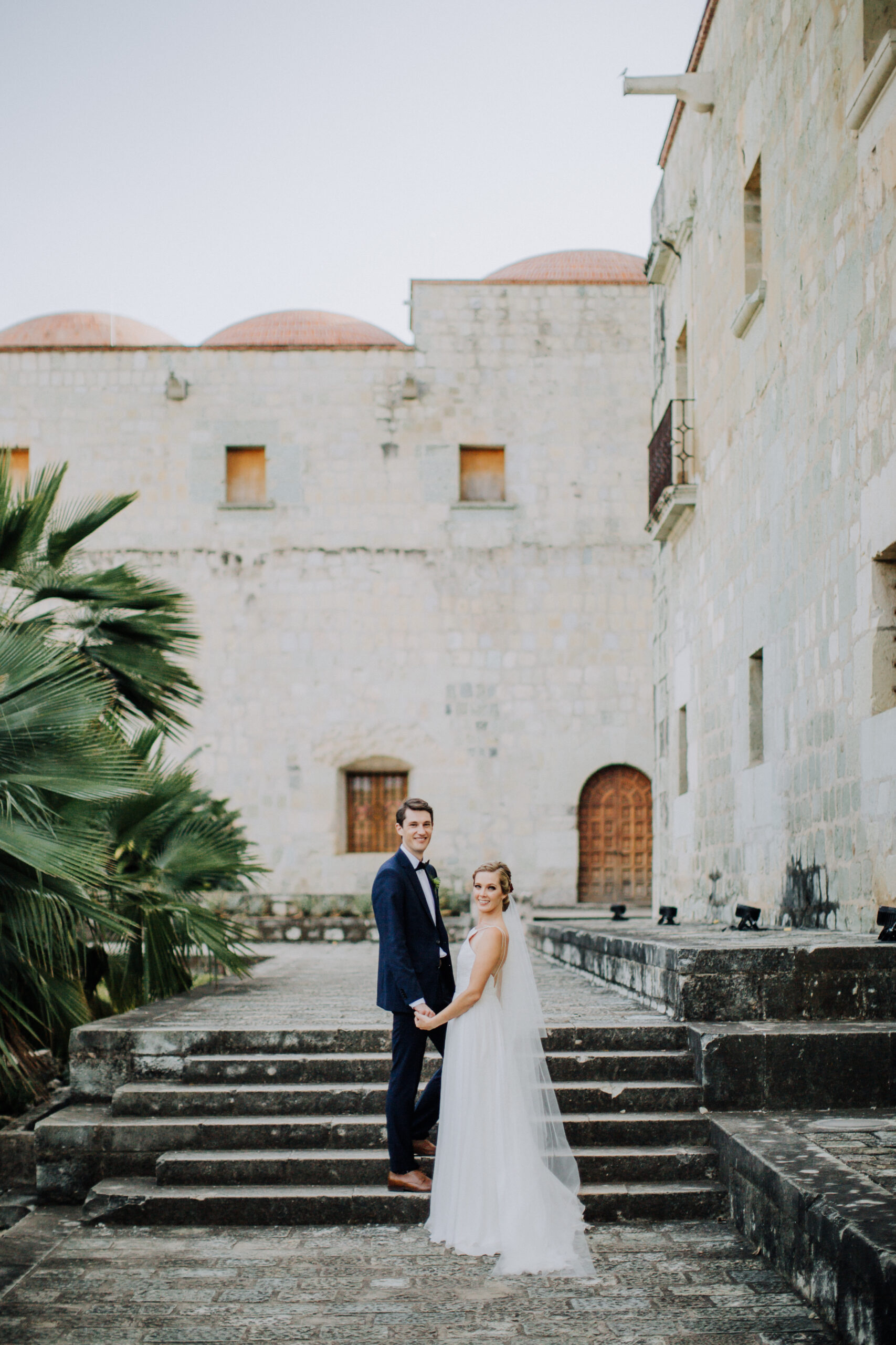 Stunning bride and groom pose in front of a stunning church after their stunning Oaxaca Wedding 