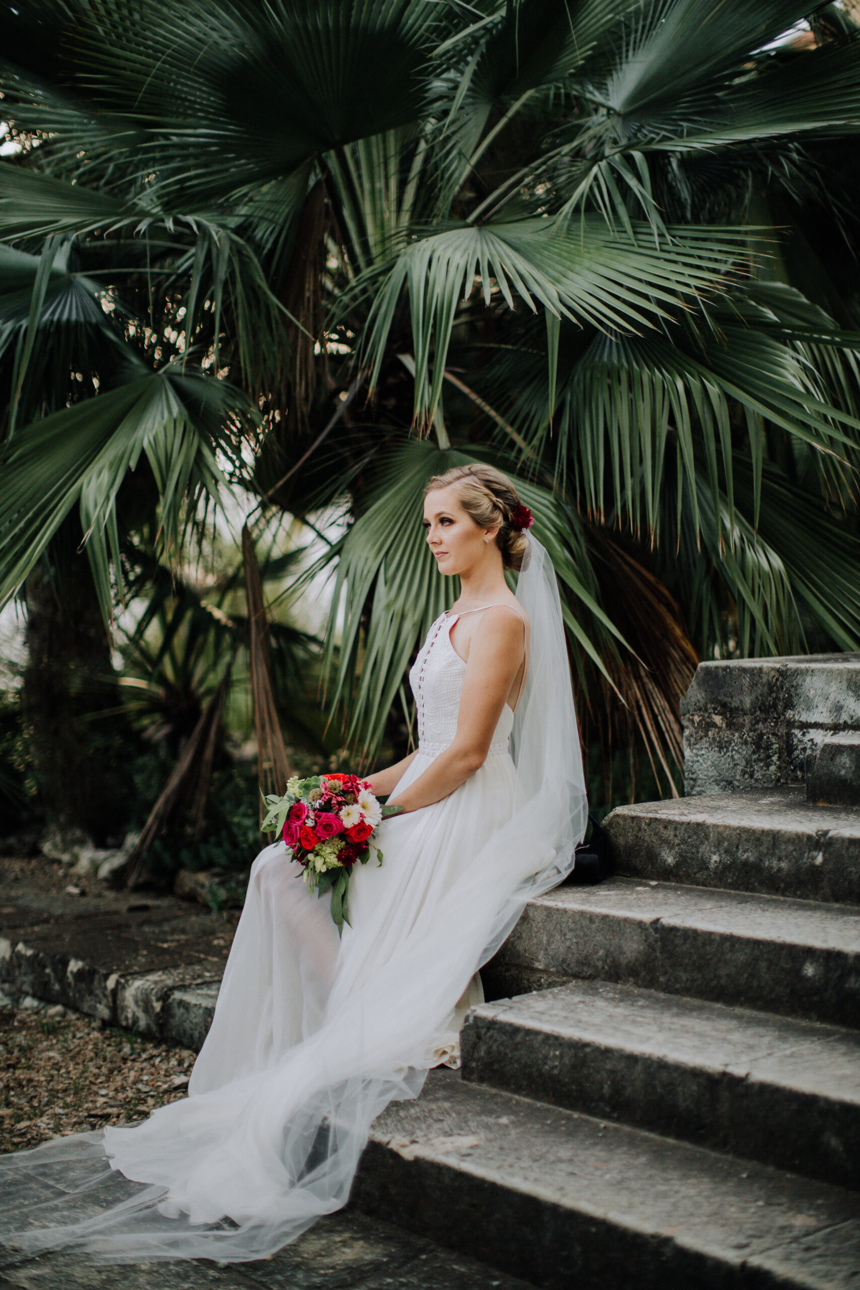 bride sits in the lush Mexican garden 