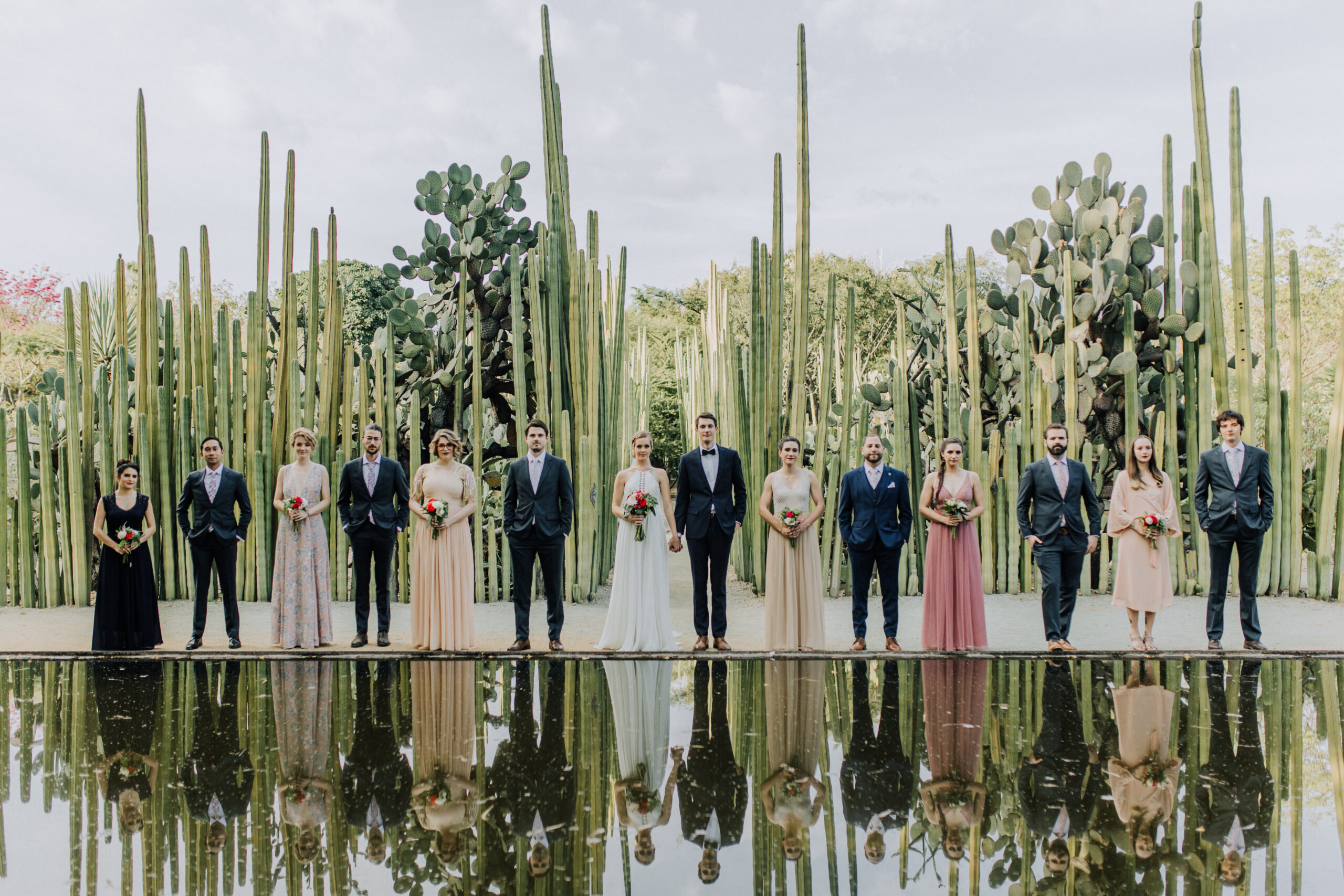 Stunning bride and groom pose in the cactus garden with their wedding party after their dreamy Oaxaca Wedding 