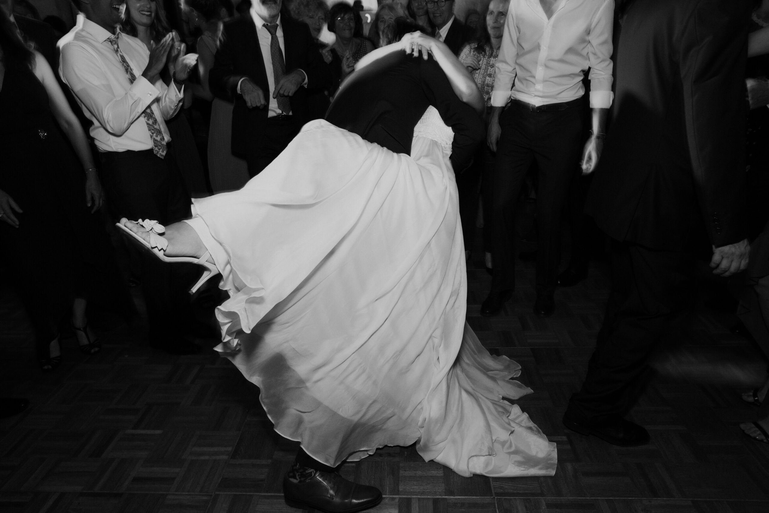 bride and groom share a kiss as they exit the dance floor