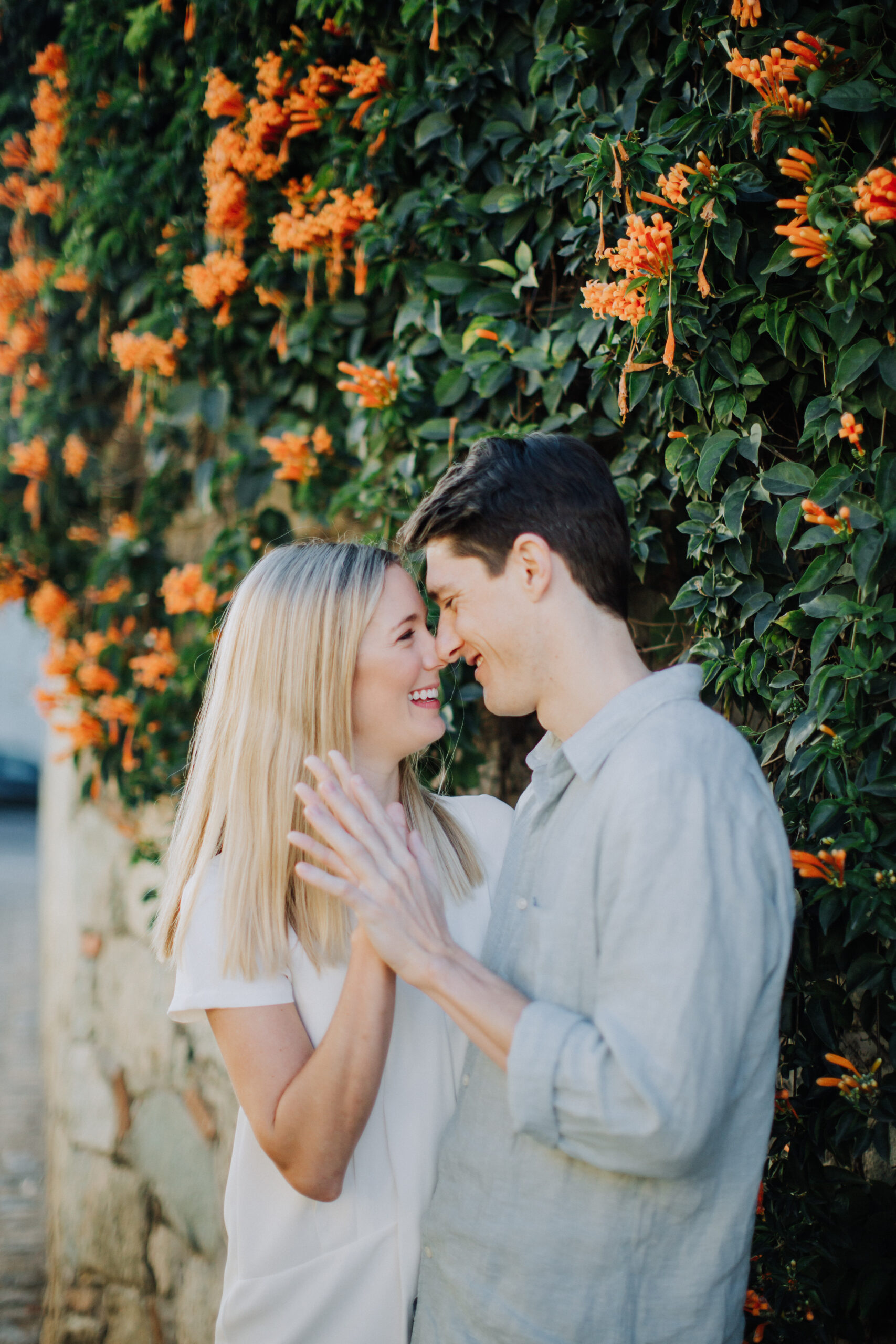beautiful couple pose in front of stunning orange flowers