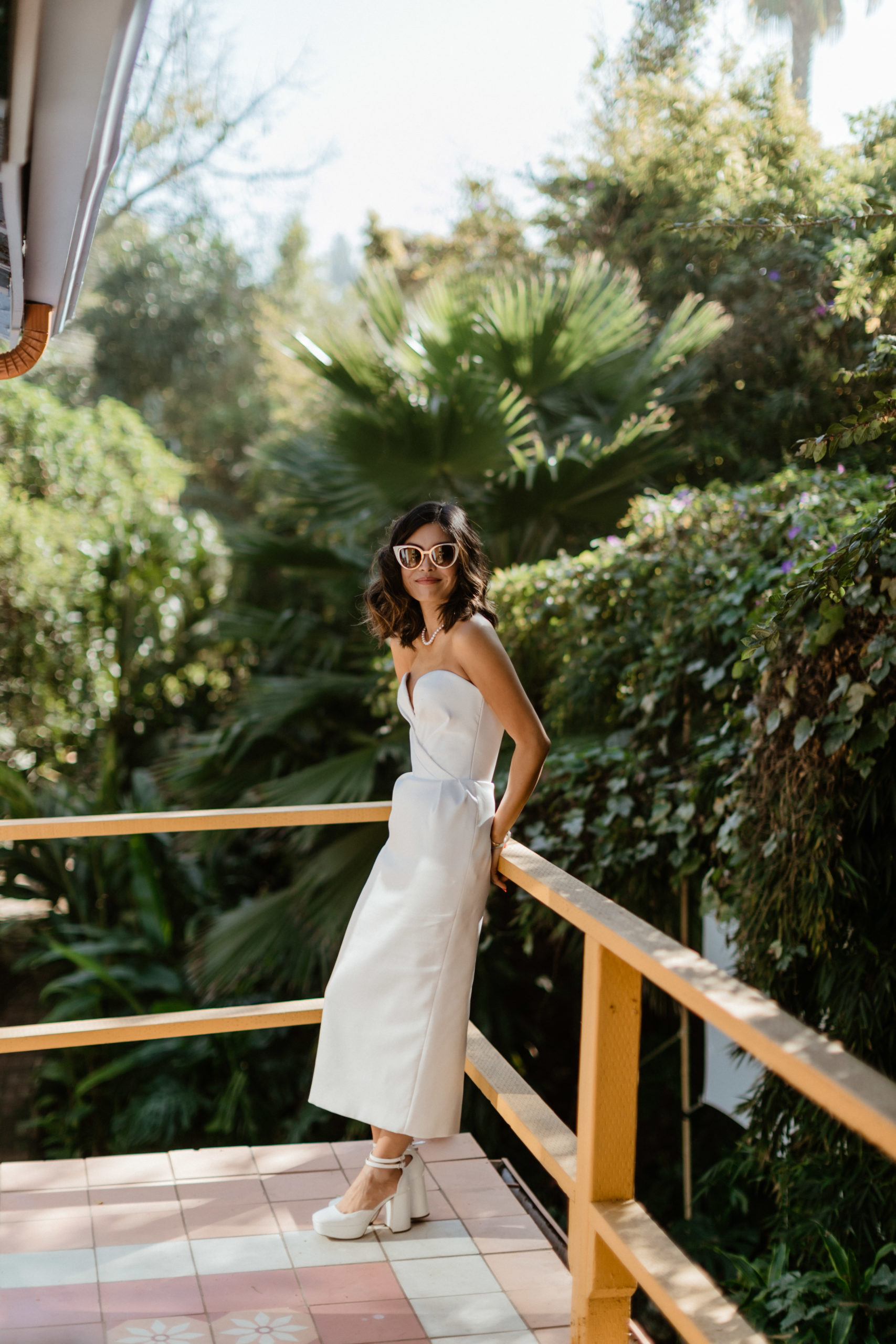 bride poses on the porch of her stunning LA home