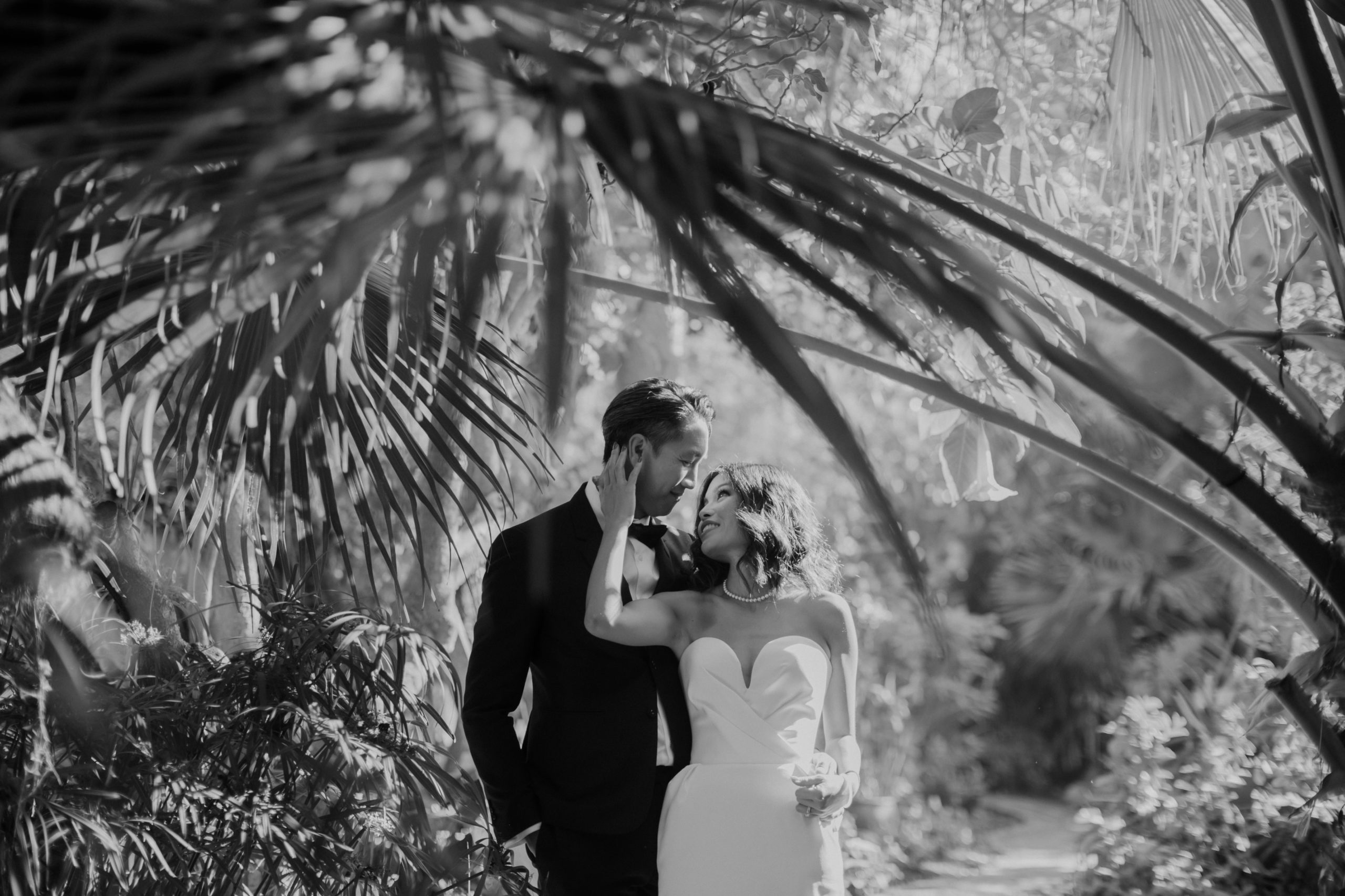 bride and groom pose outside in their lush garden