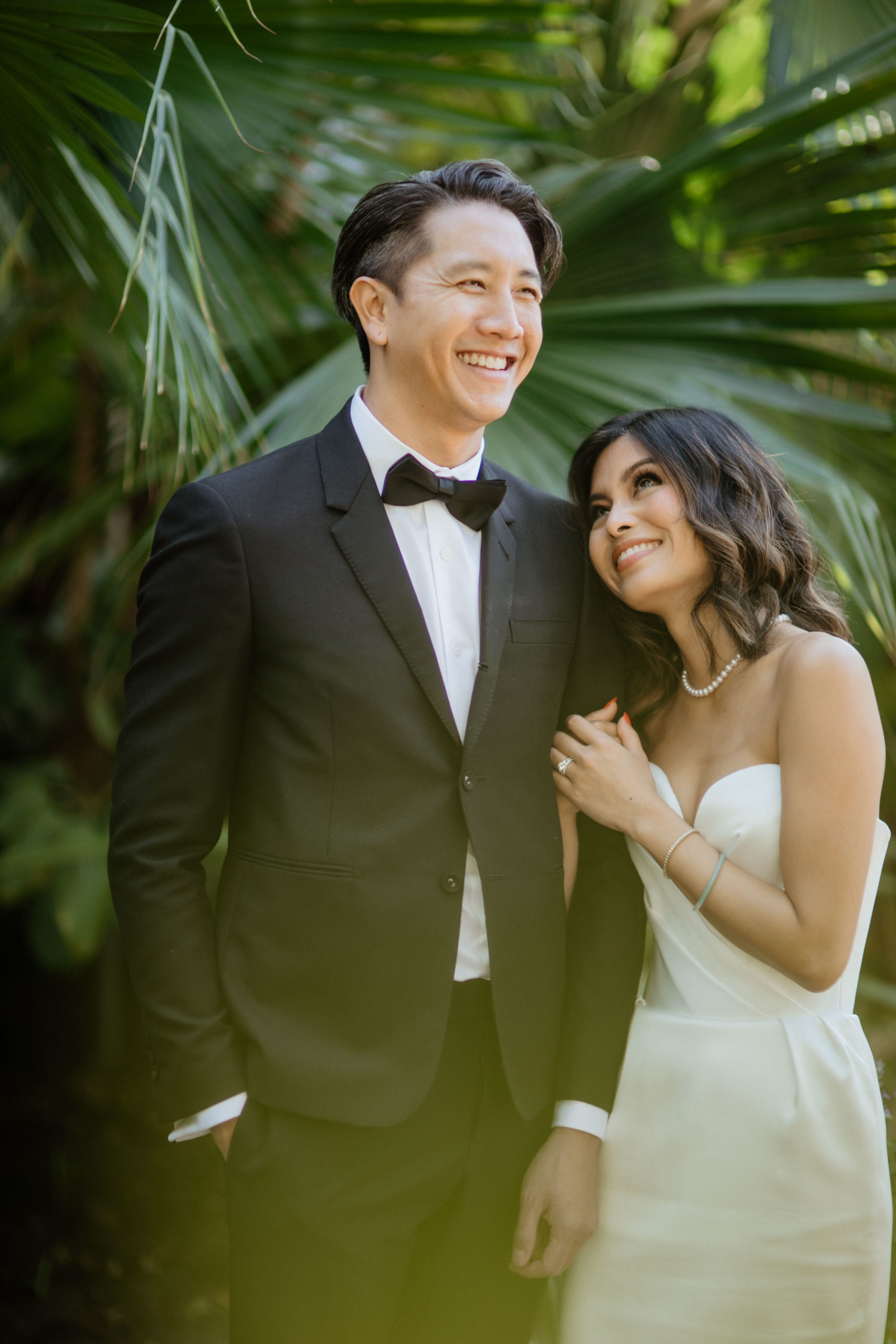 bride and groom pose outside in their lush garden