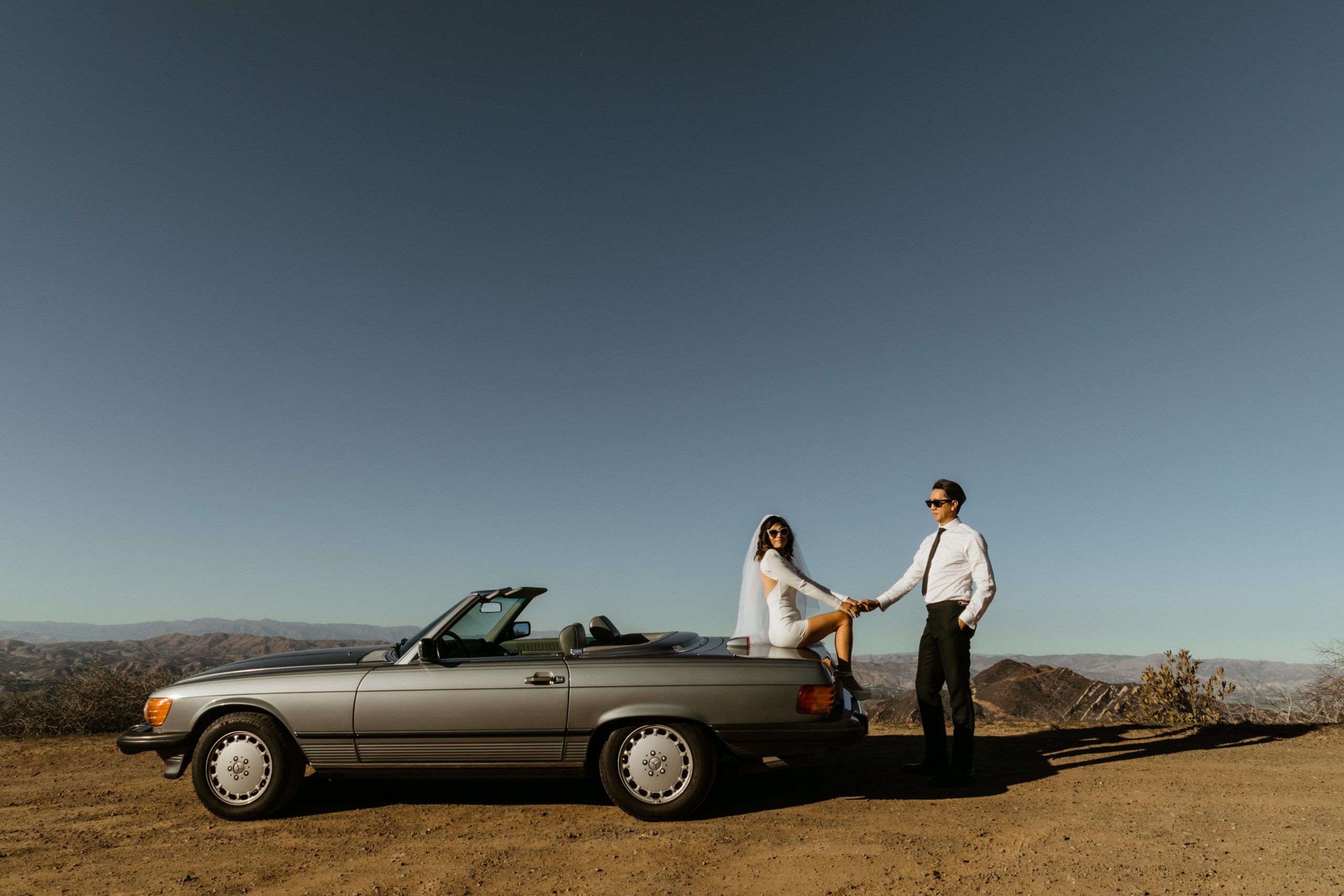 bride and groom pose together overlooking the LA mountains