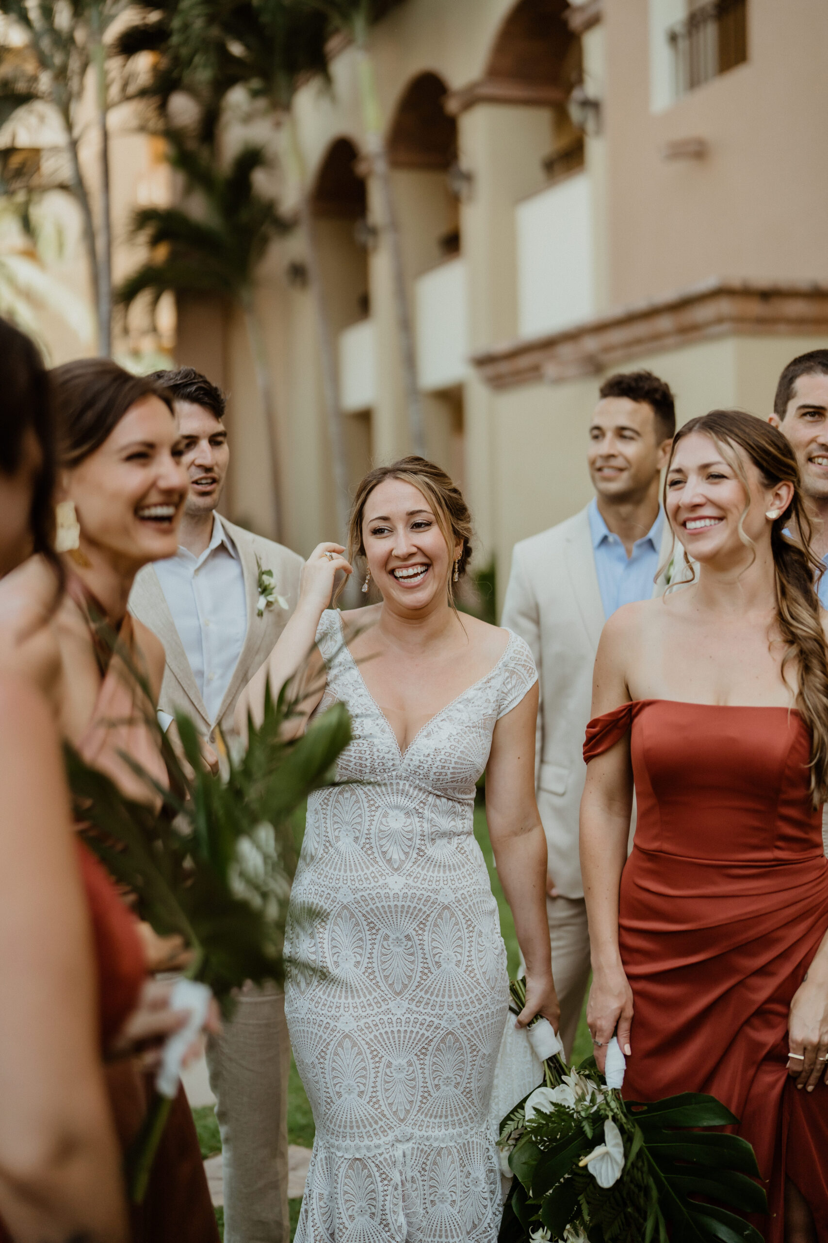 bride laughing with bridesmaids at destination beach wedding.