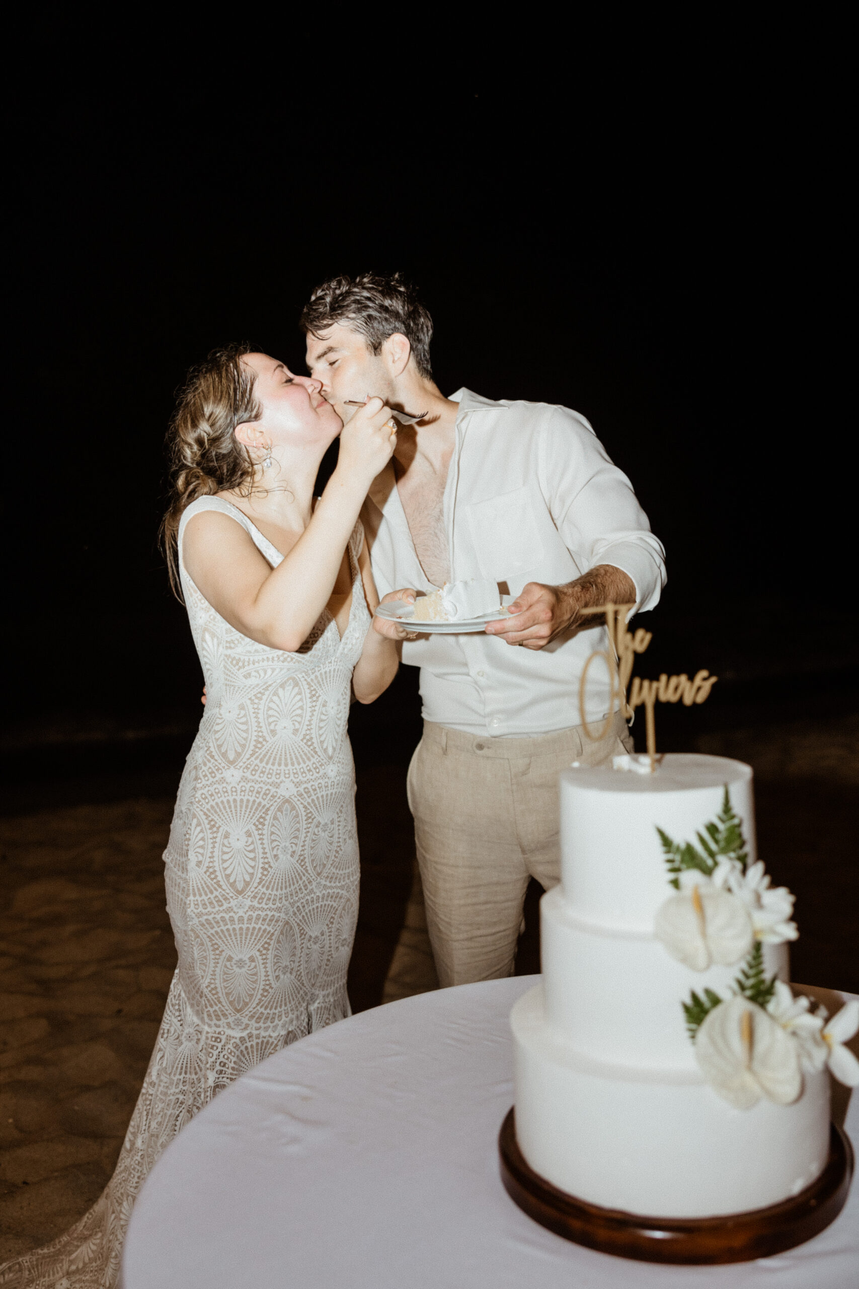 bride and groom eating wedding cake together.
