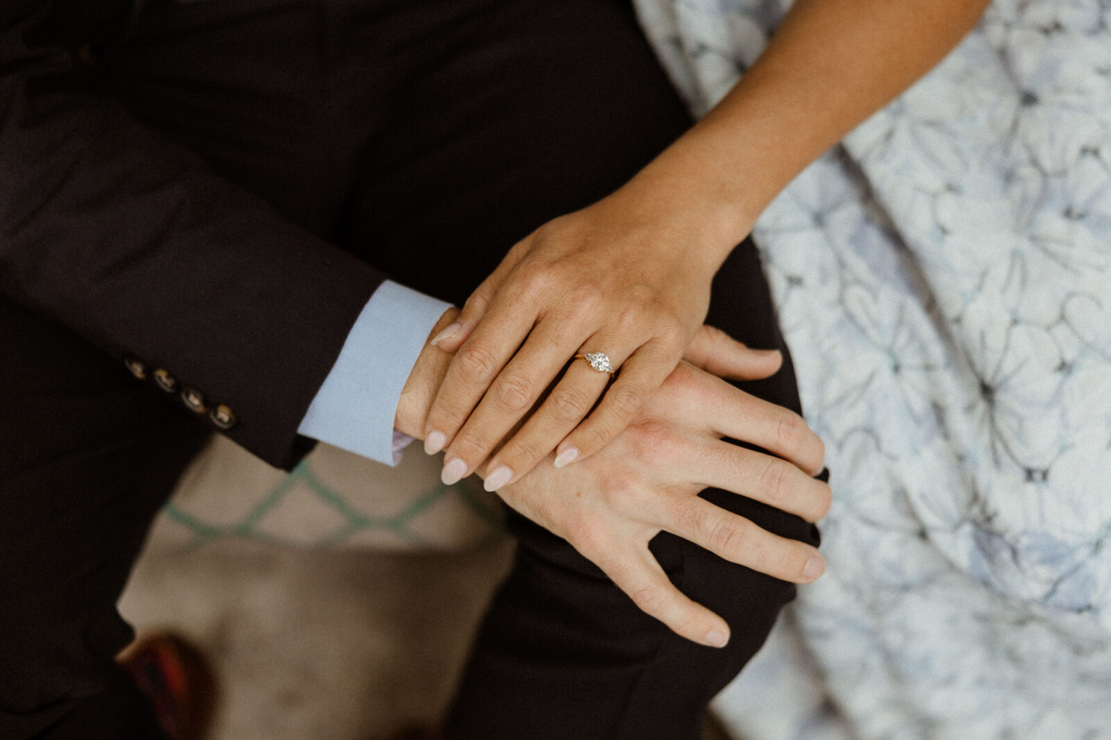 Woman with engagement ring holding mans hand. 