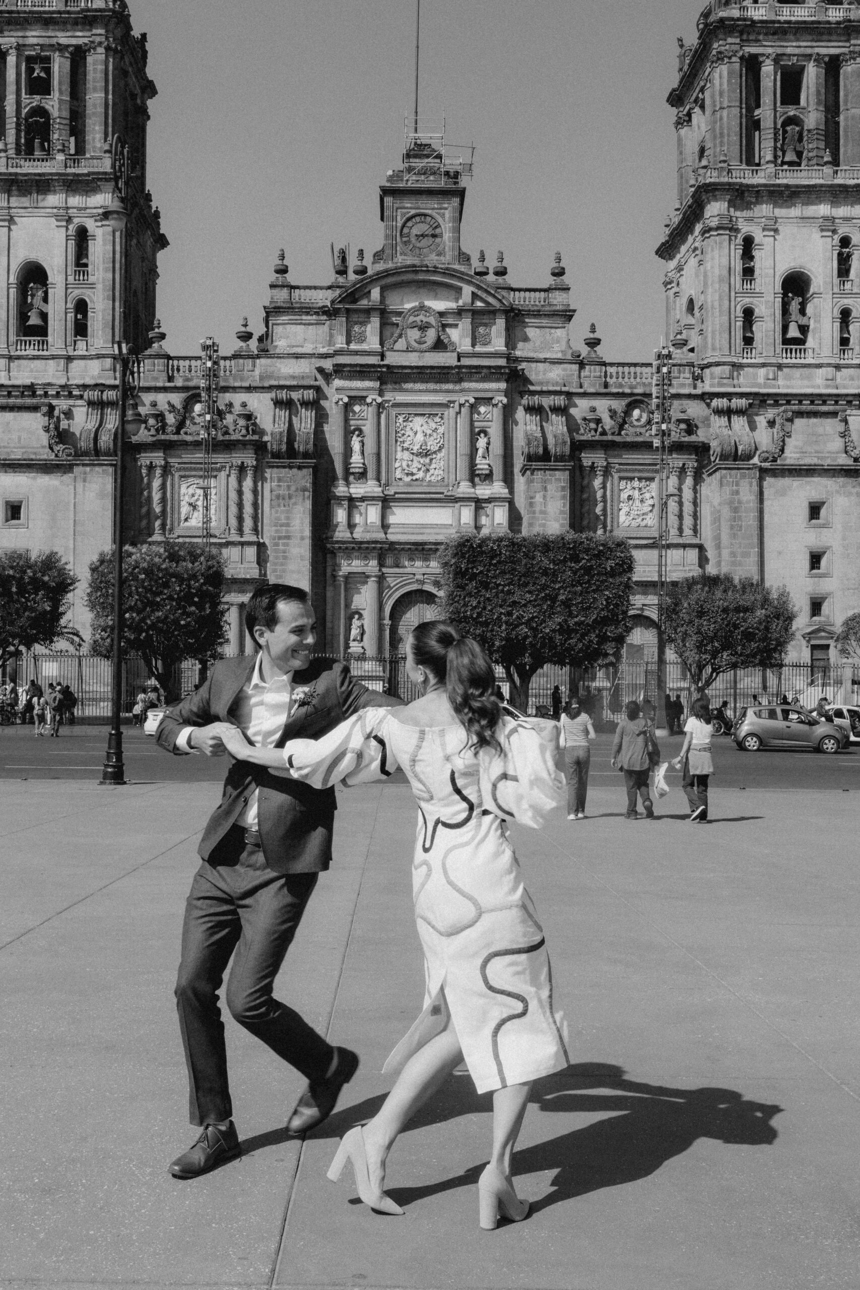 man and woman in white dress dancing in streets of Mexico city. 