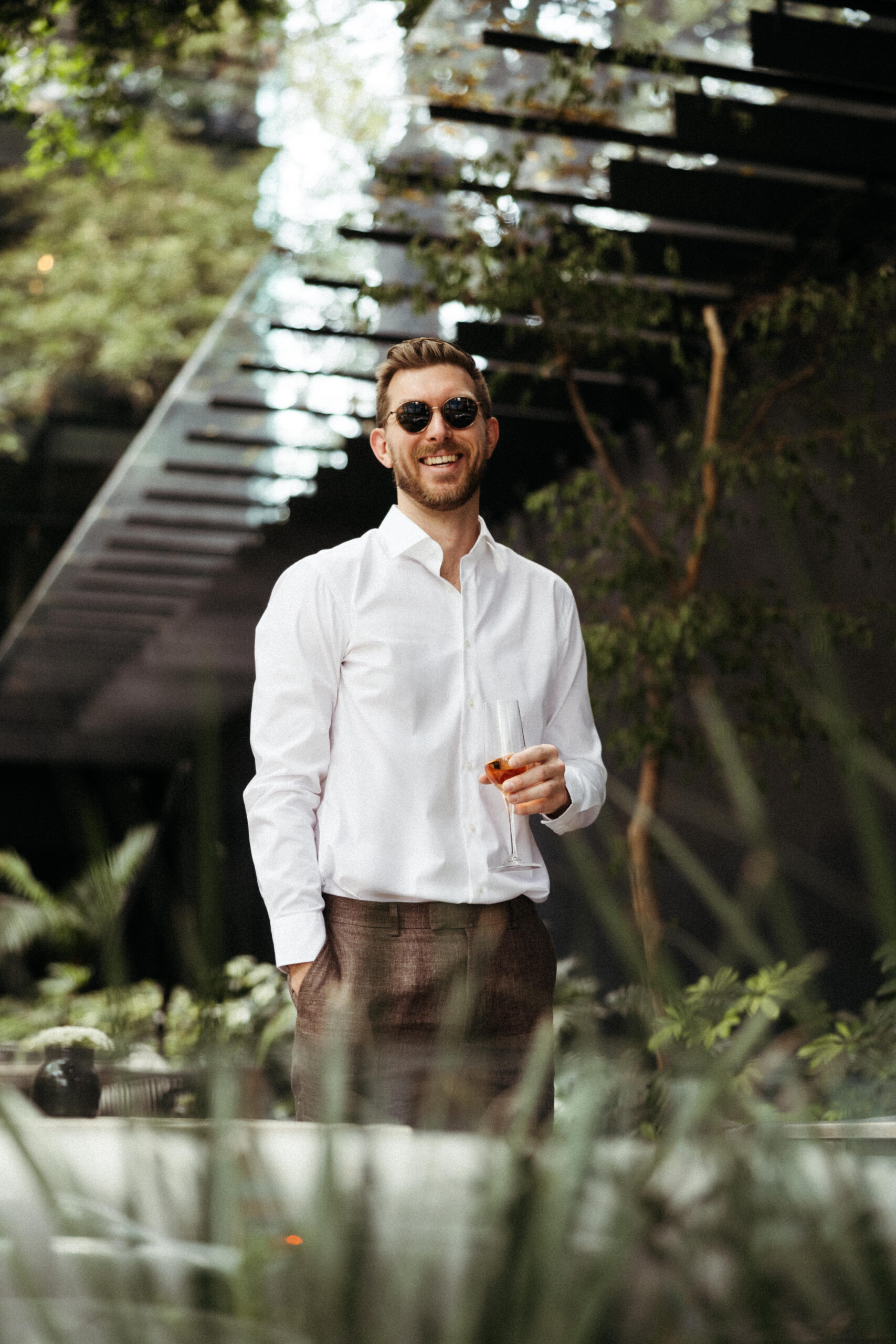 groom in white shirt with sunglass on outdoors.