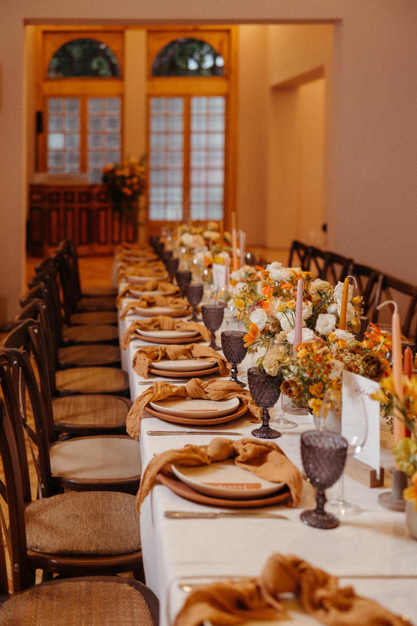 elegant dinner table with bright orange floral arrangements. 