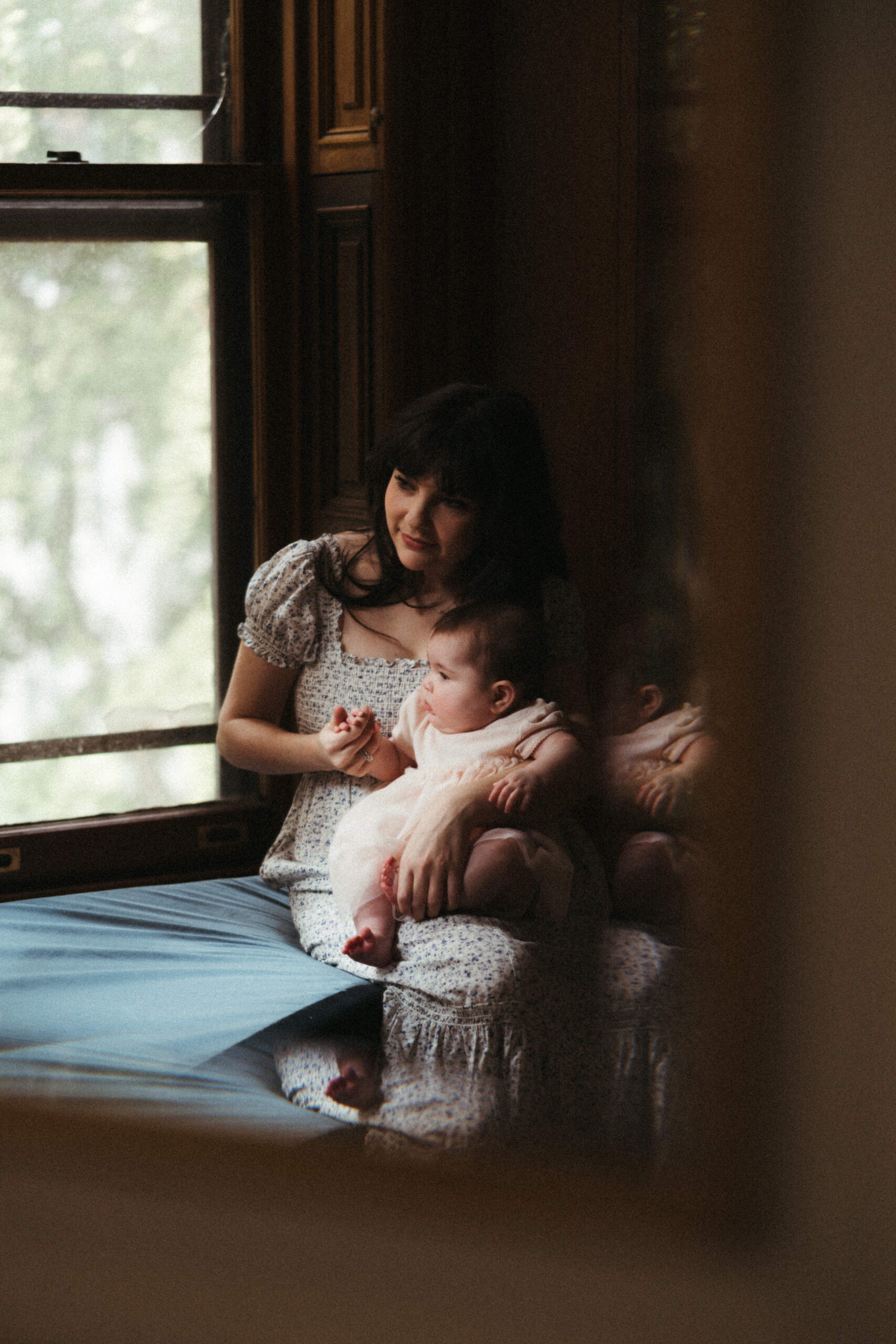 a photo of mom and infant daughter sharing a quiet moment together during their in home photo session