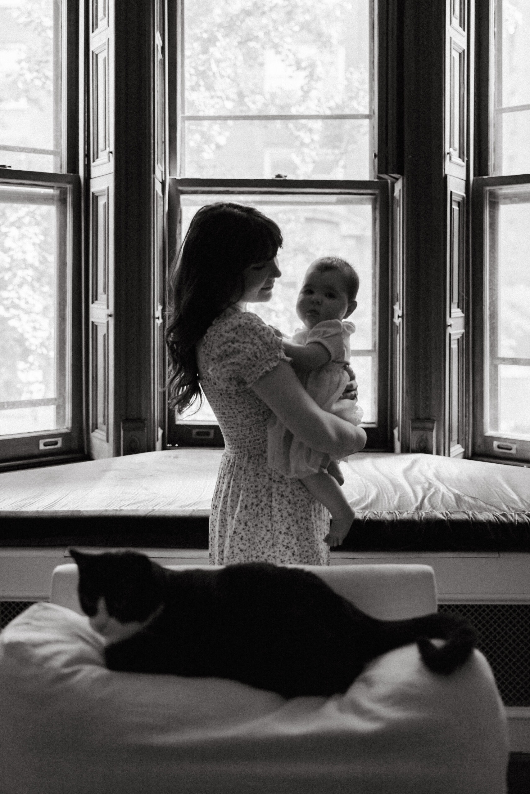 Black and white intimate photo of mom and infant daughter together during their in home photo session