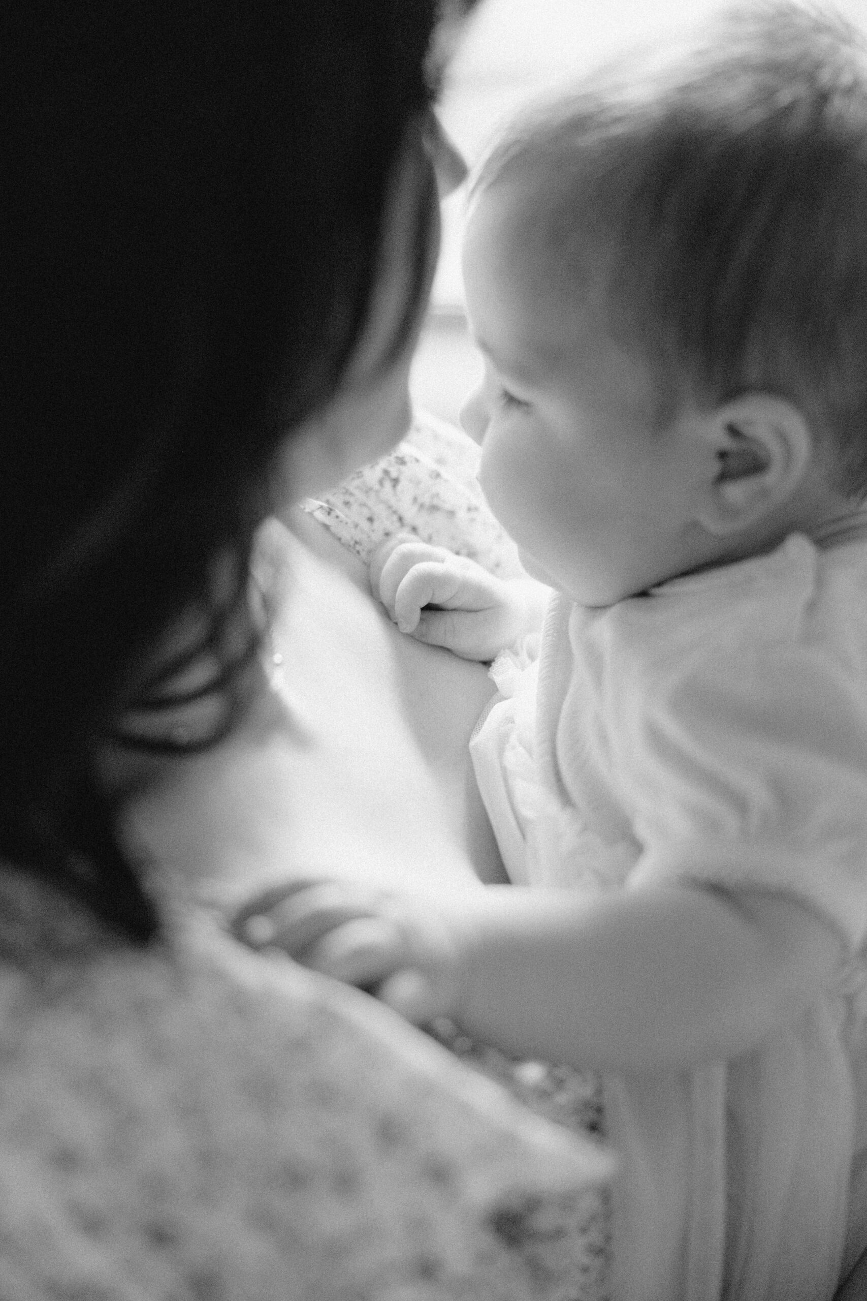 Black and white intimate photo of mom and infant daughter together during their in home photo session