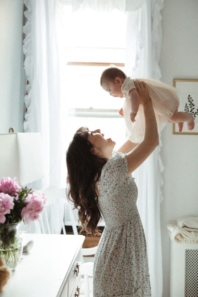 Mom plays rocketship with her infant daughter during their candid in home photo session