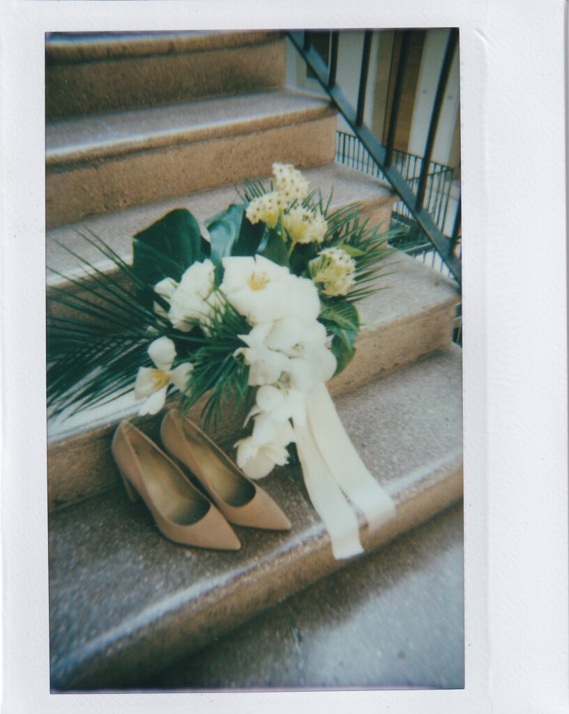 film photo of brides shoes and white florals. 