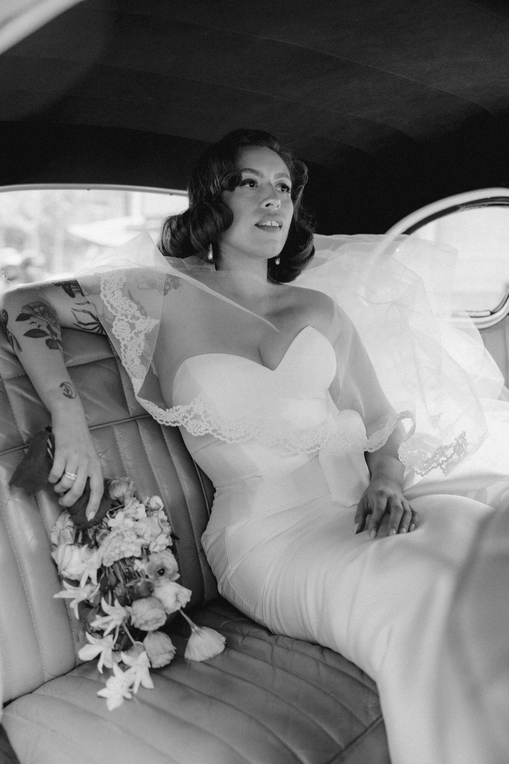 Stunning bride poses in the getaway car before her Mexico destination wedding
