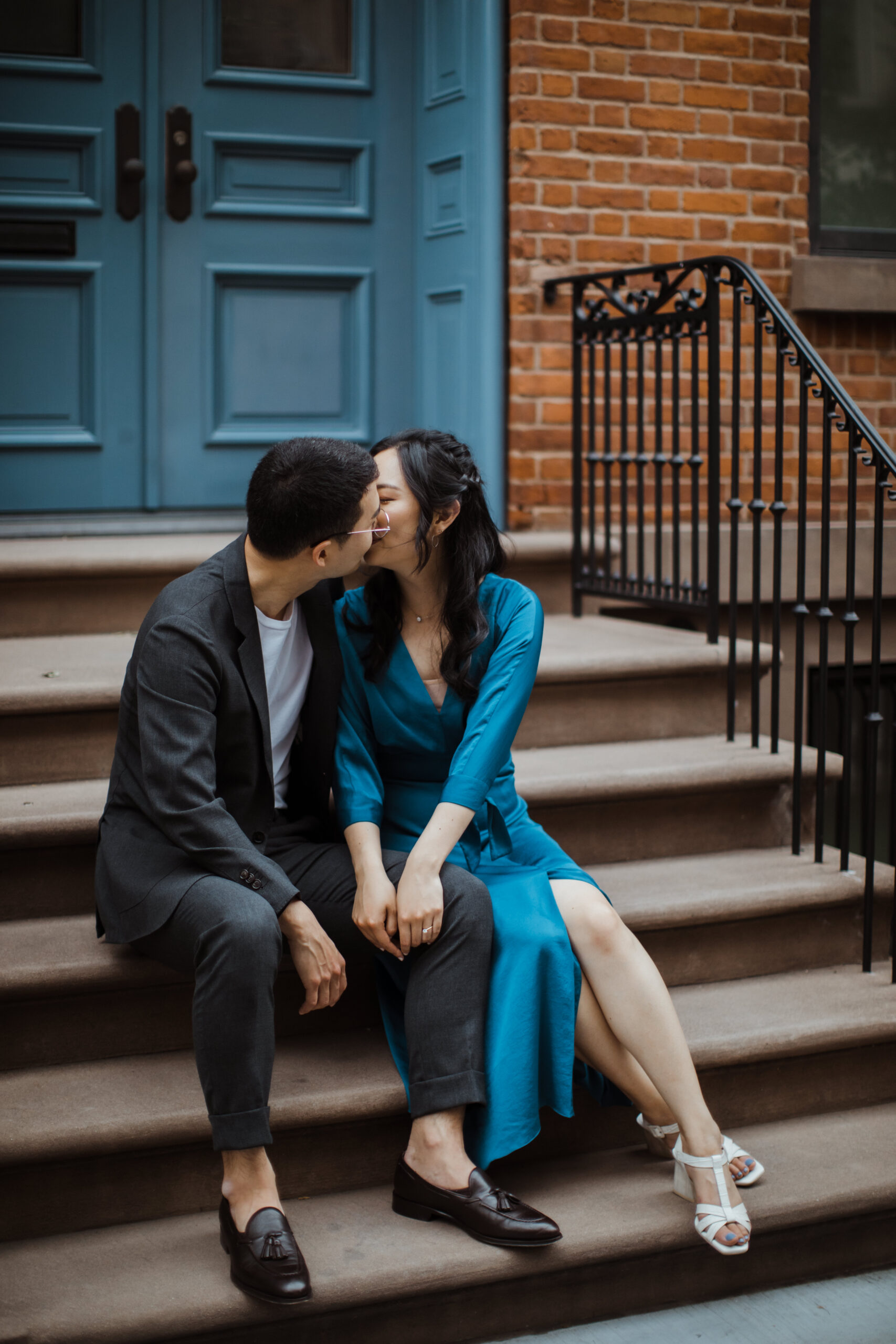 Beautiful couple shares a kiss on the steps in the West Village during their New York engagement session