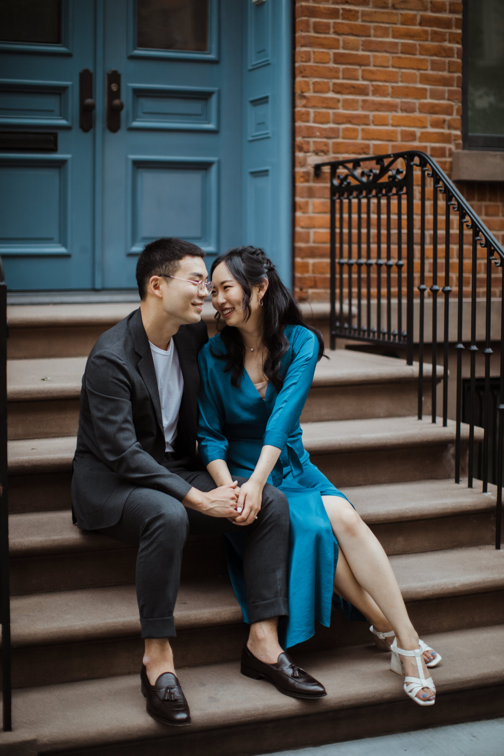 Stunning couple sit on a stoop in the West Village during their New York Engagement