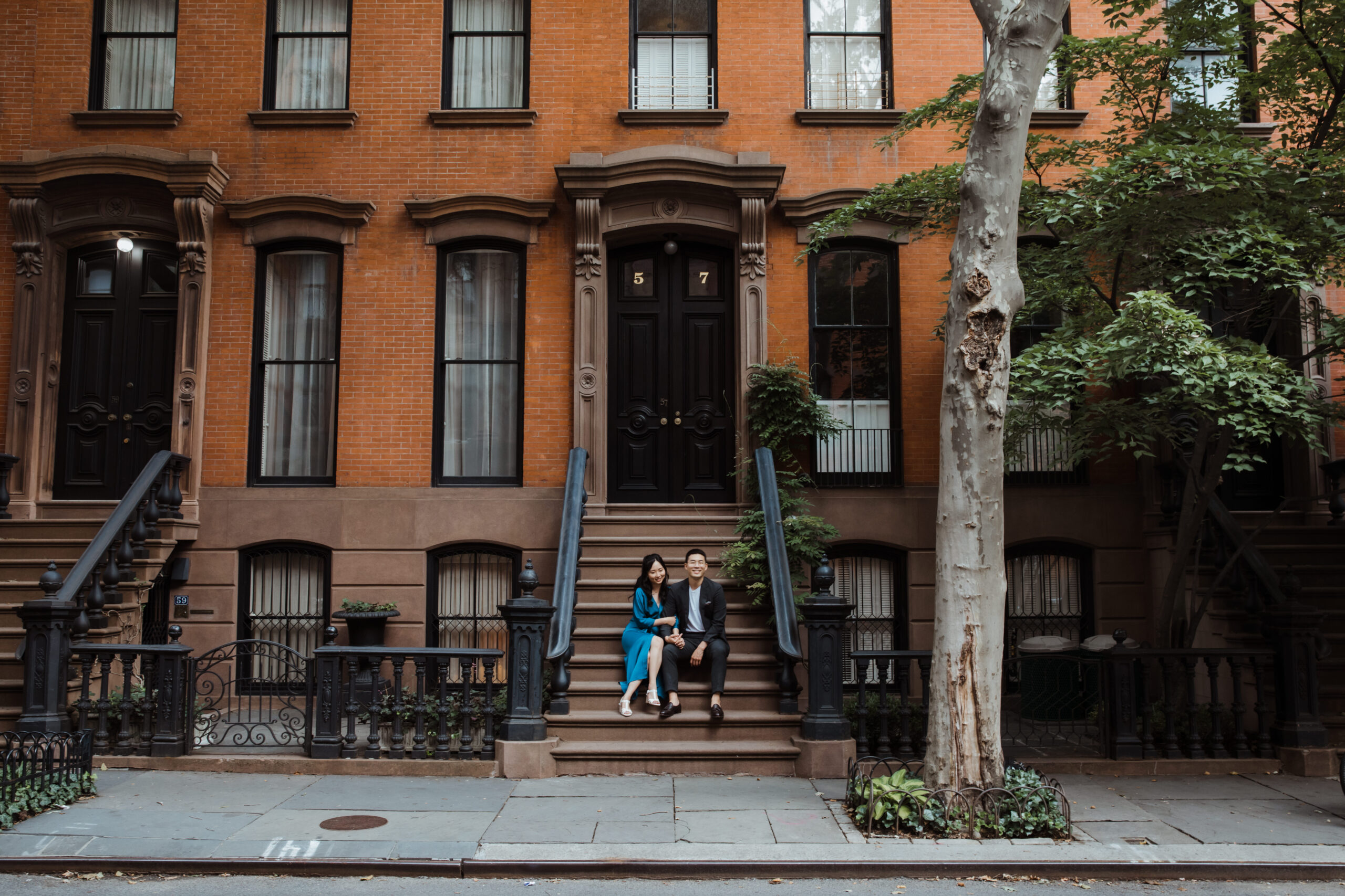 Beautiful couple sits on the steps in the West Village during their romantic West Village engagement photos