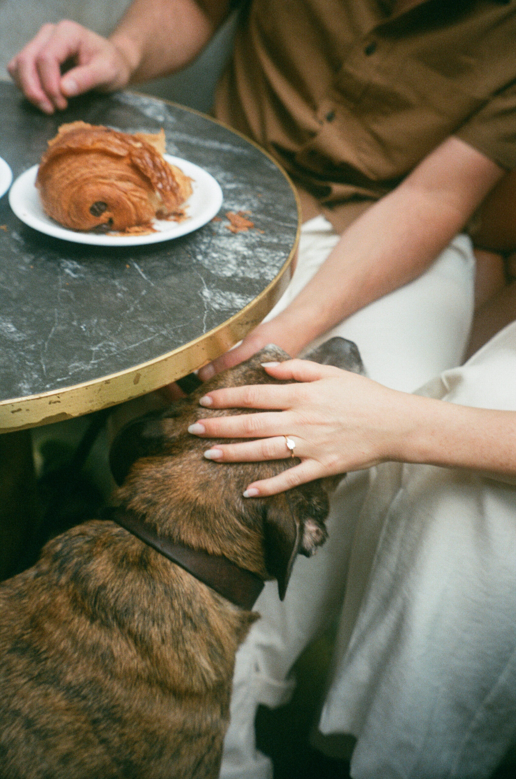 film photo with engagement ring and candid photography of croissant 