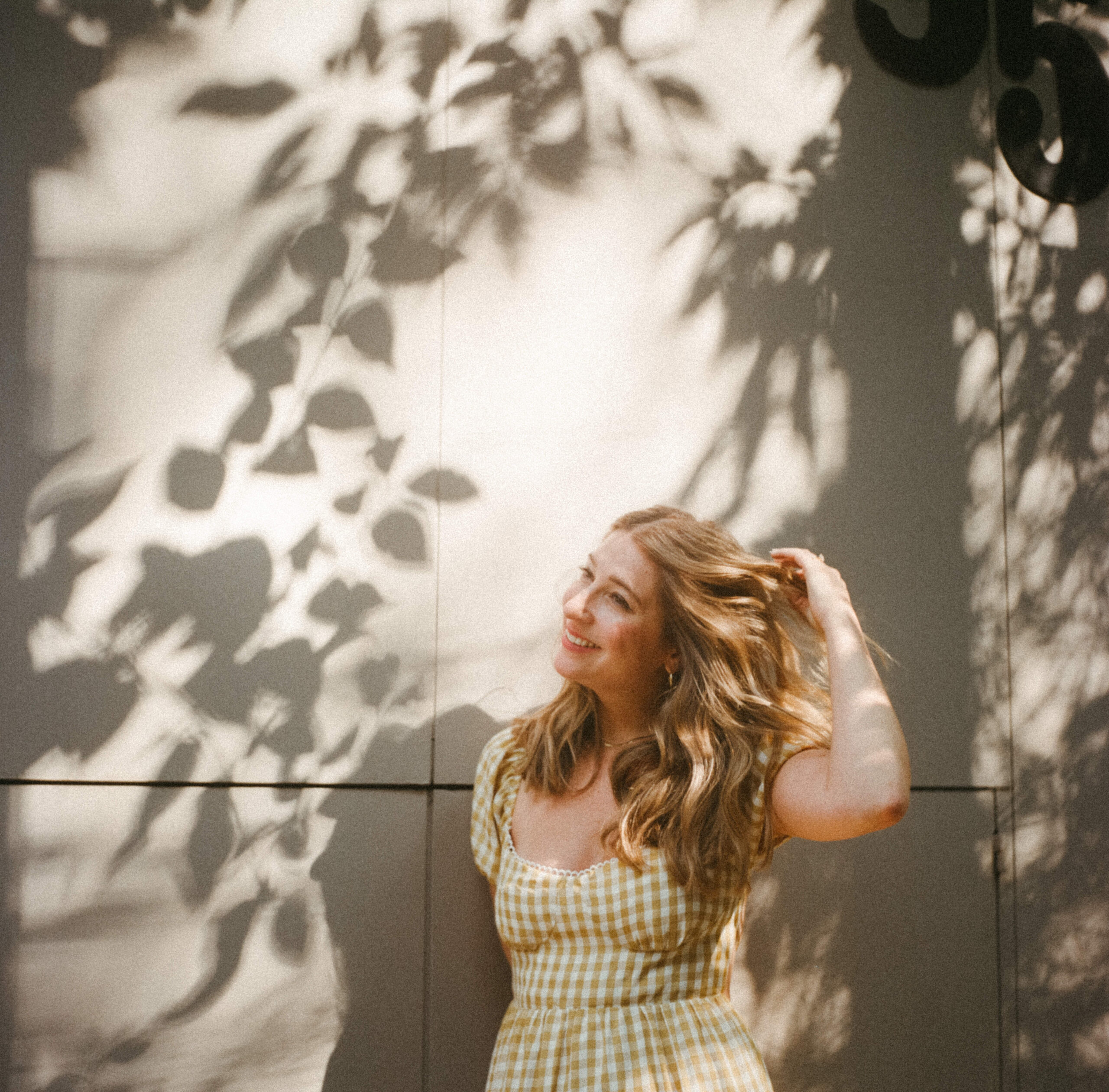 stunning fiance flipping hair while in a gingham yellow dress