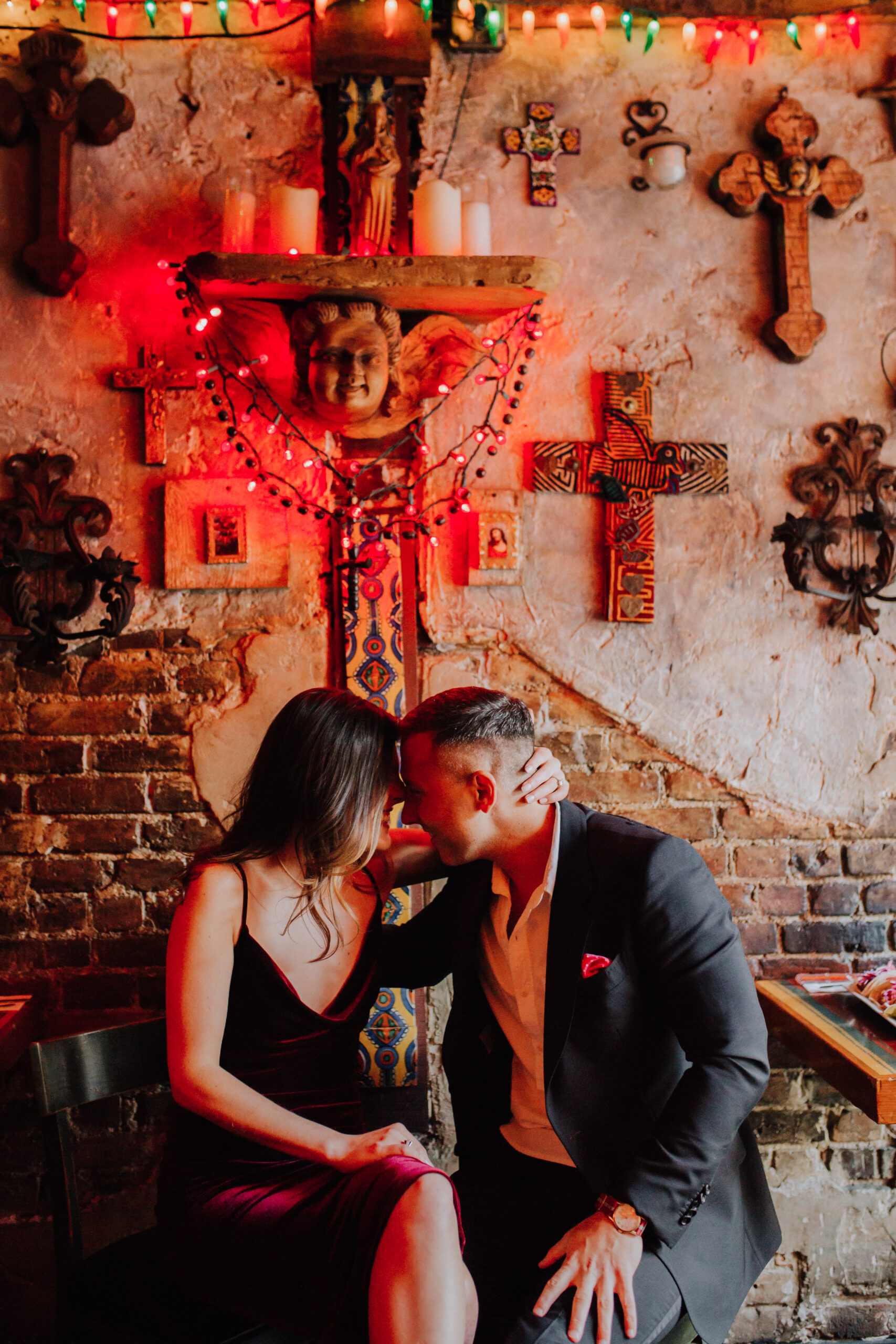 Beautiful couple share an intimate moment in front of wall of crosses 