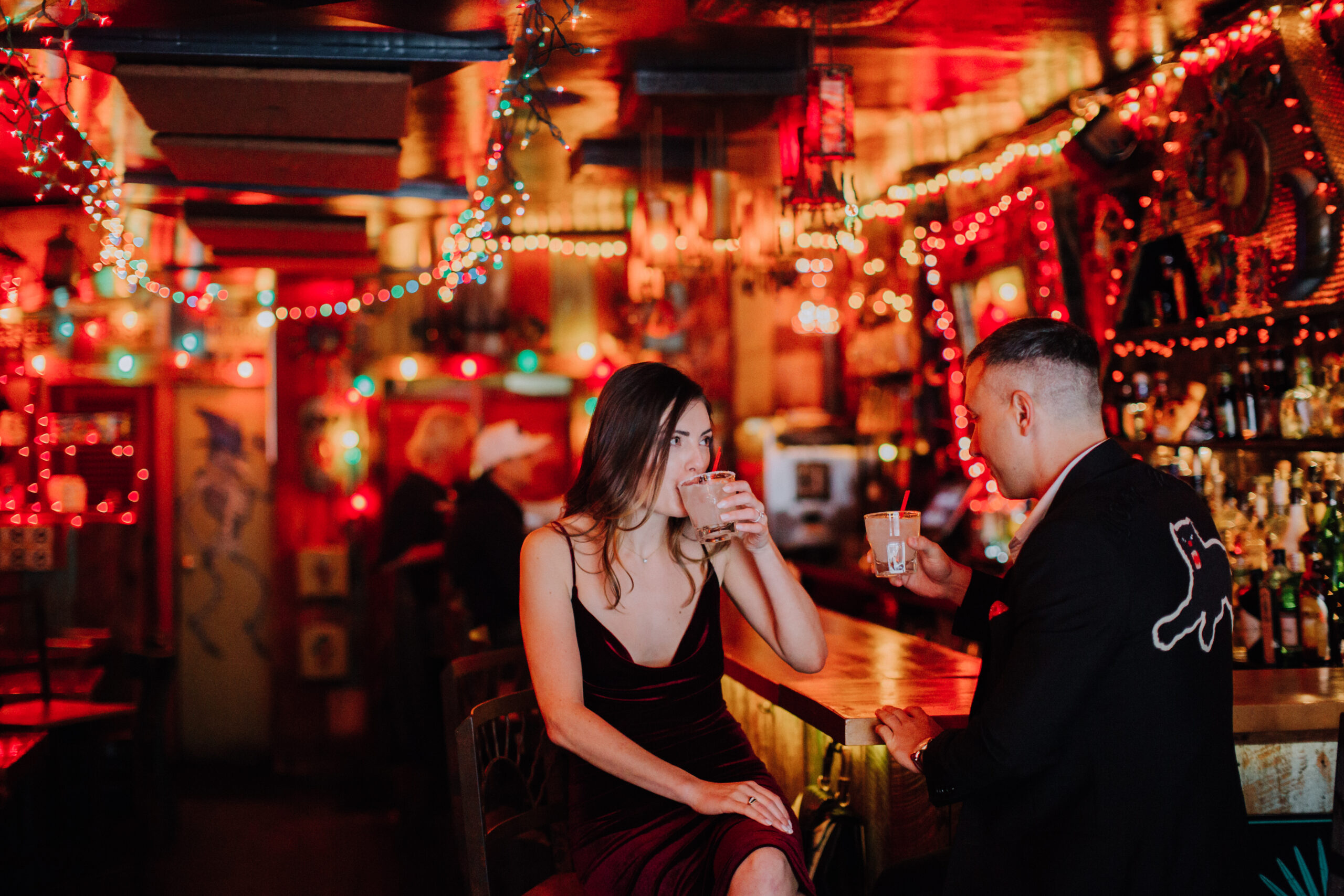 Stunning couple sip drinks at the bar during their New York City engagement photos