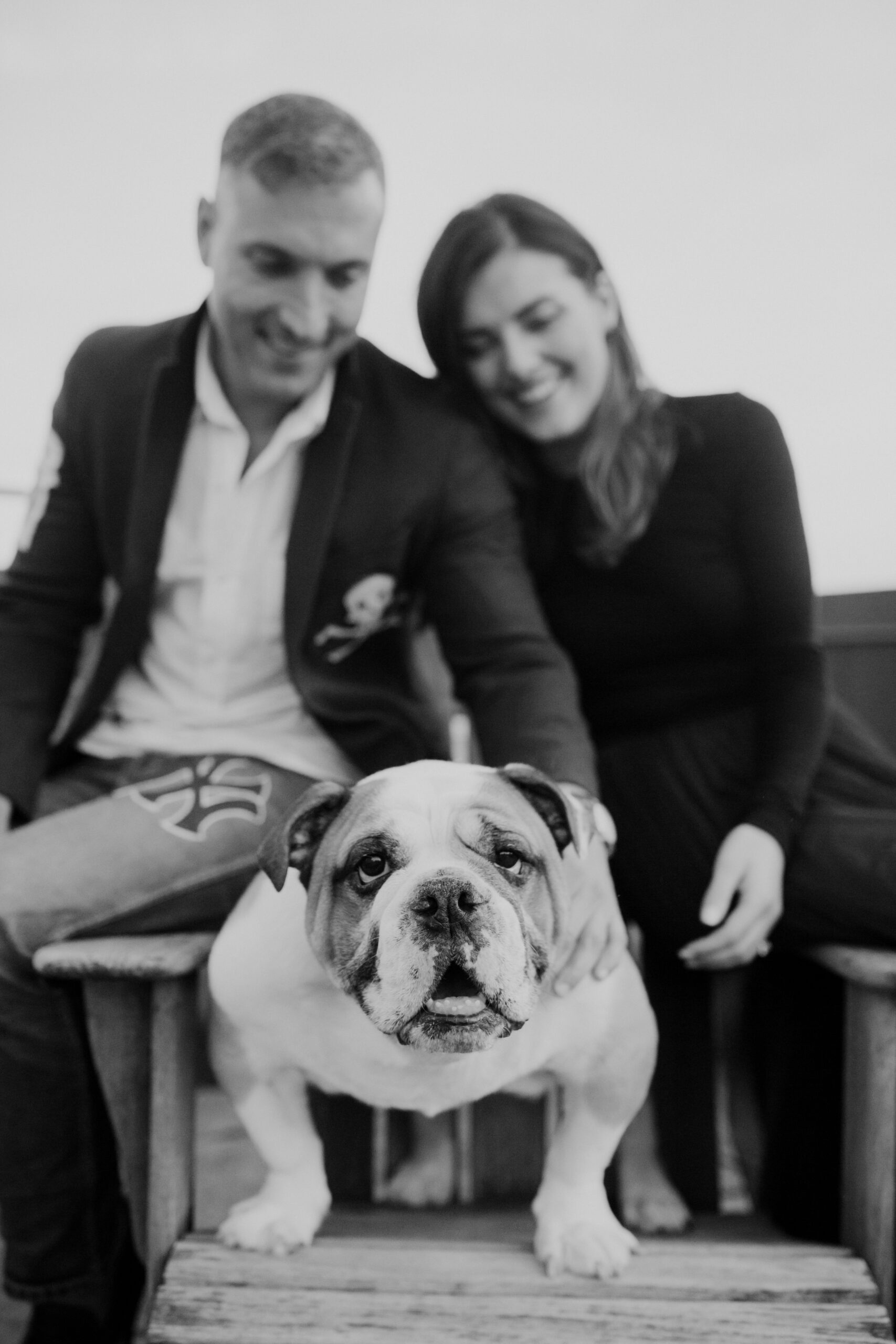 black and white photo of couple with their dog in apartment. 