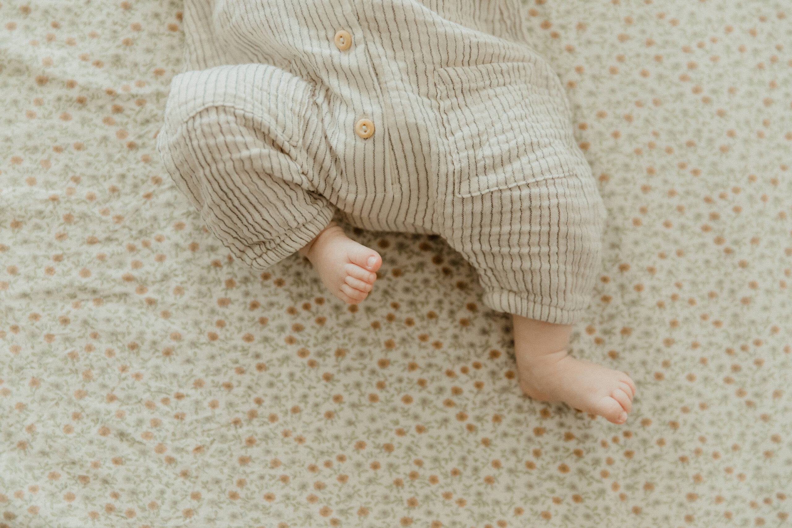 photo of an infant's little toes on a patterned sheet