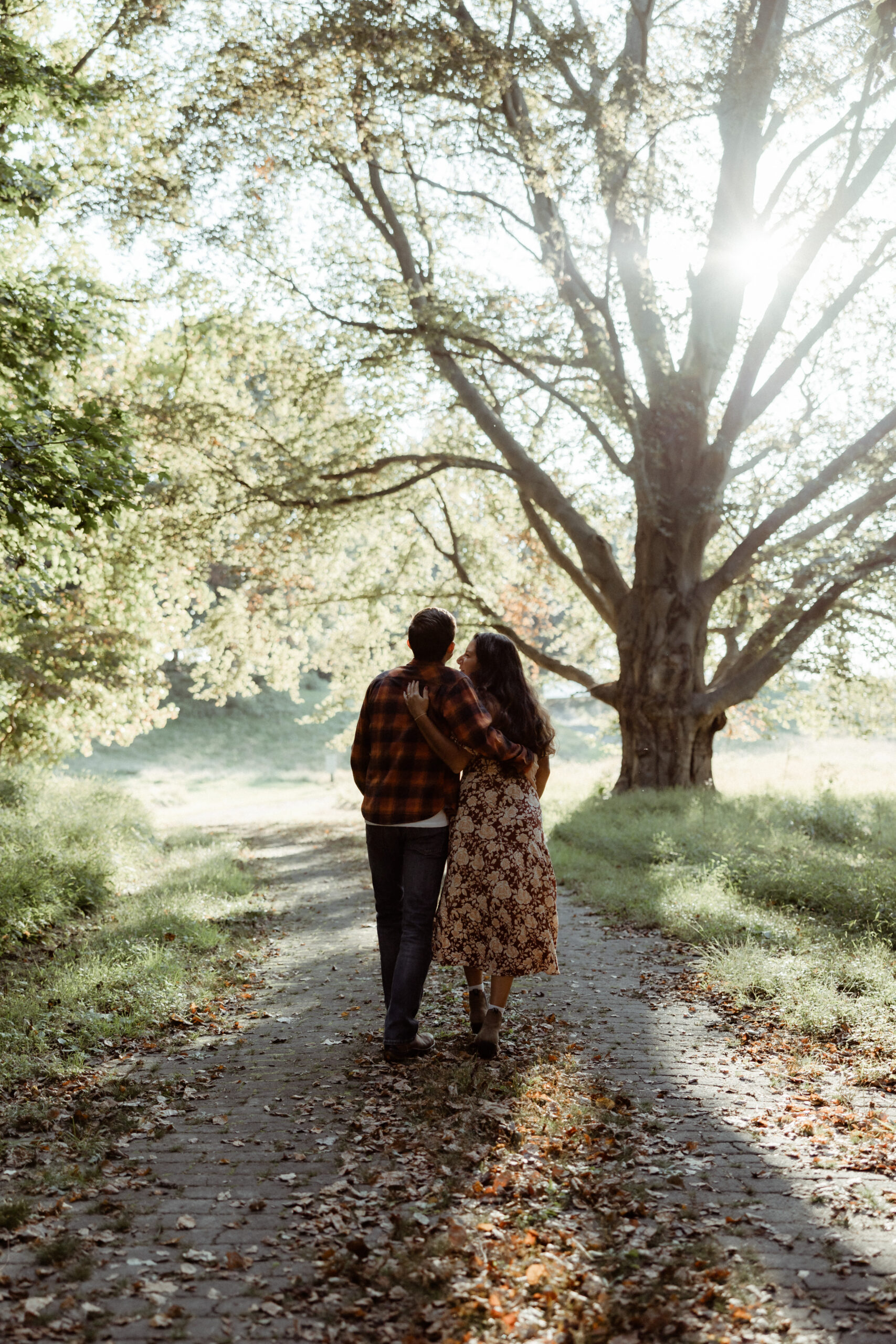 Beautiful couple walk under the trees during their casual engagement photos