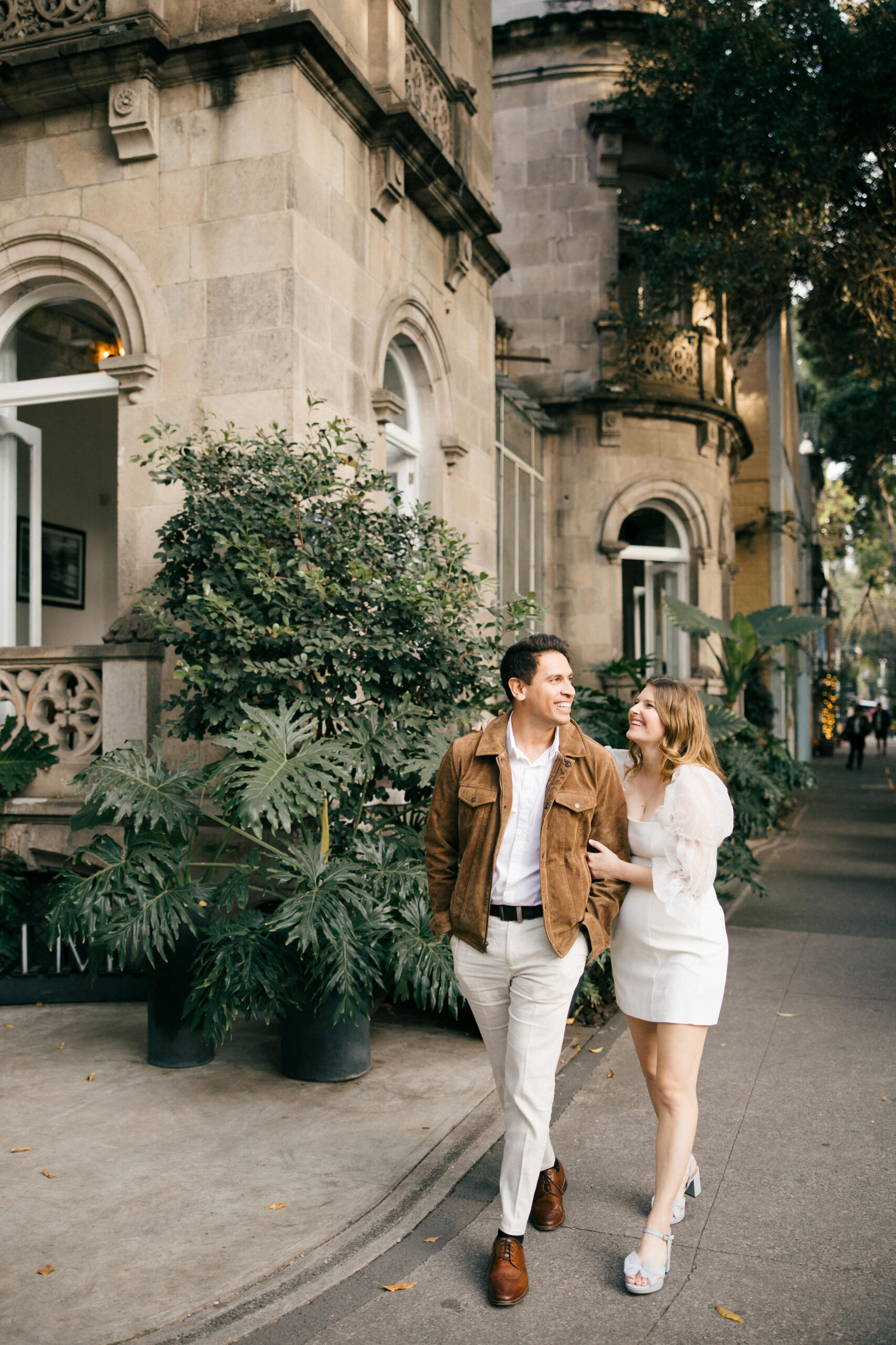Beautiful couple walk the Mexico city streets during their Mexico engagement