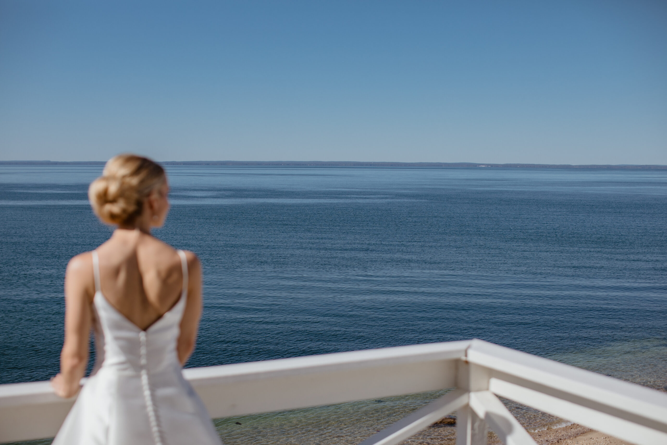 Bride looks out at the ocean in the final moments of prep before her wedding day