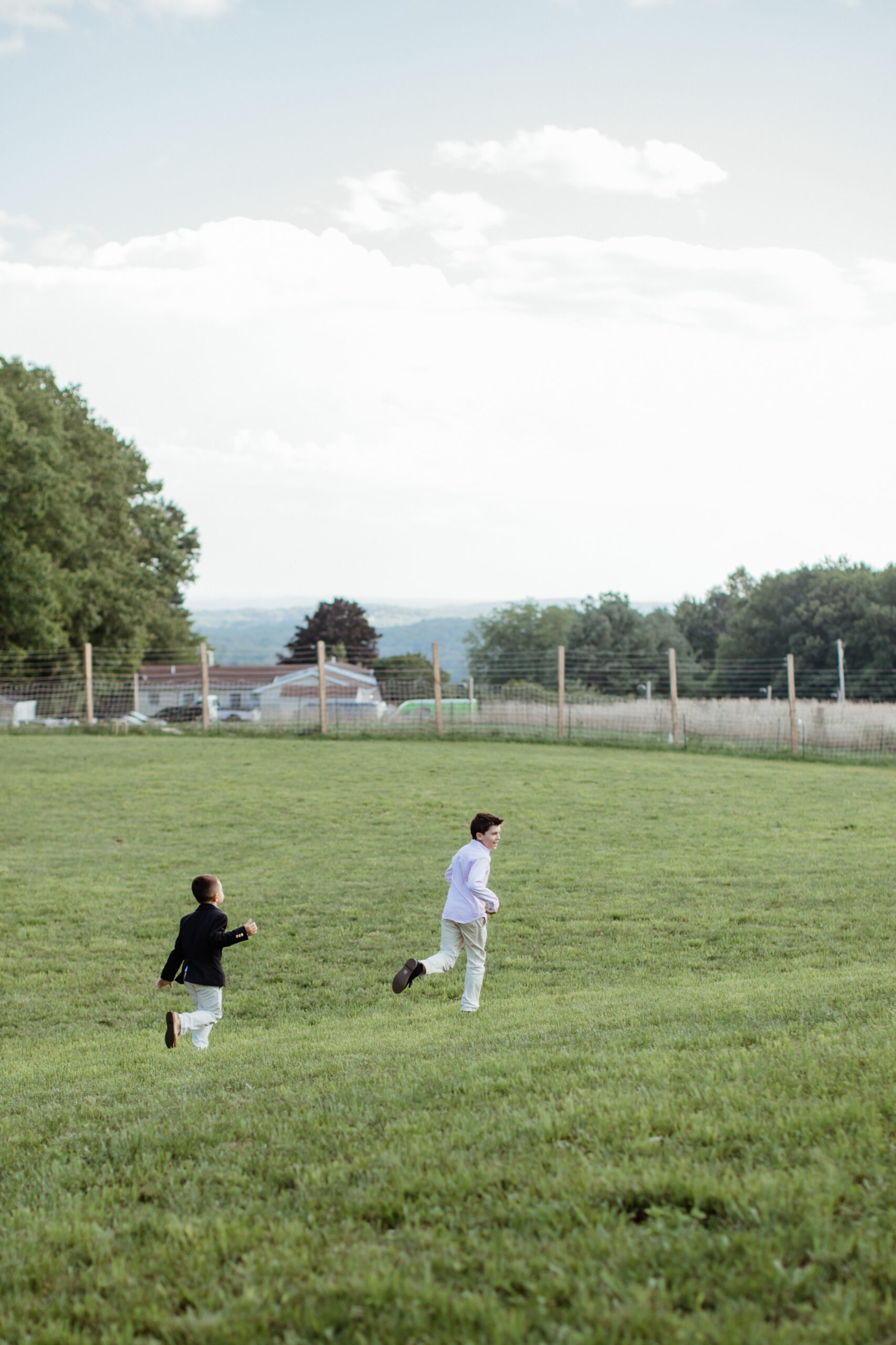 Kids run after each other laughing and playing with the stunning upstate New York mountains in the background