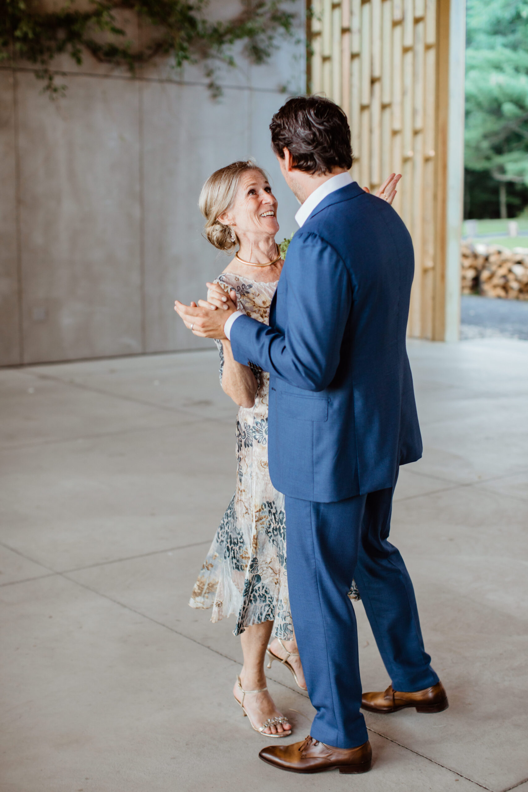 handsome son shares a dance with his mom during their modern Gather Greene wedding in Upstate New York