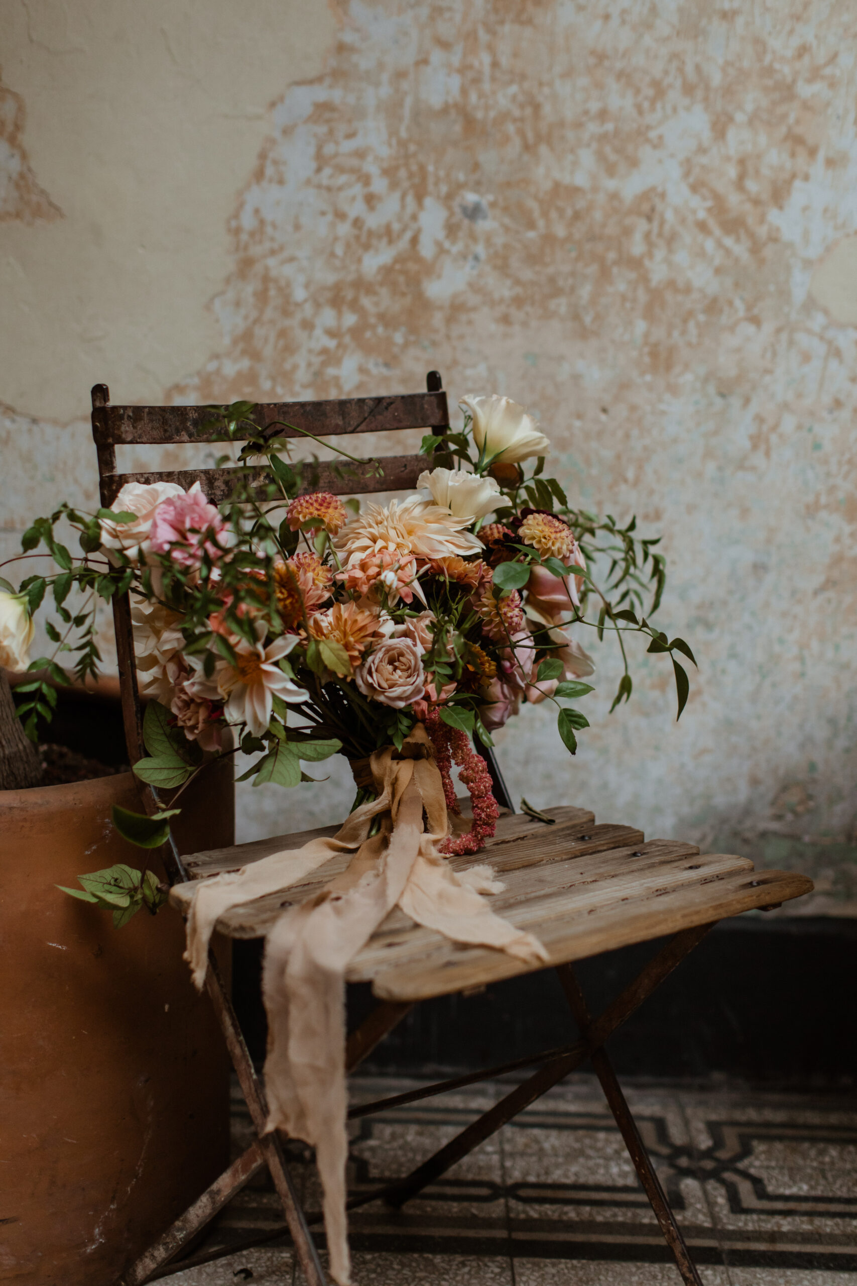 Wedding florals sit on a wooden chair for decoration