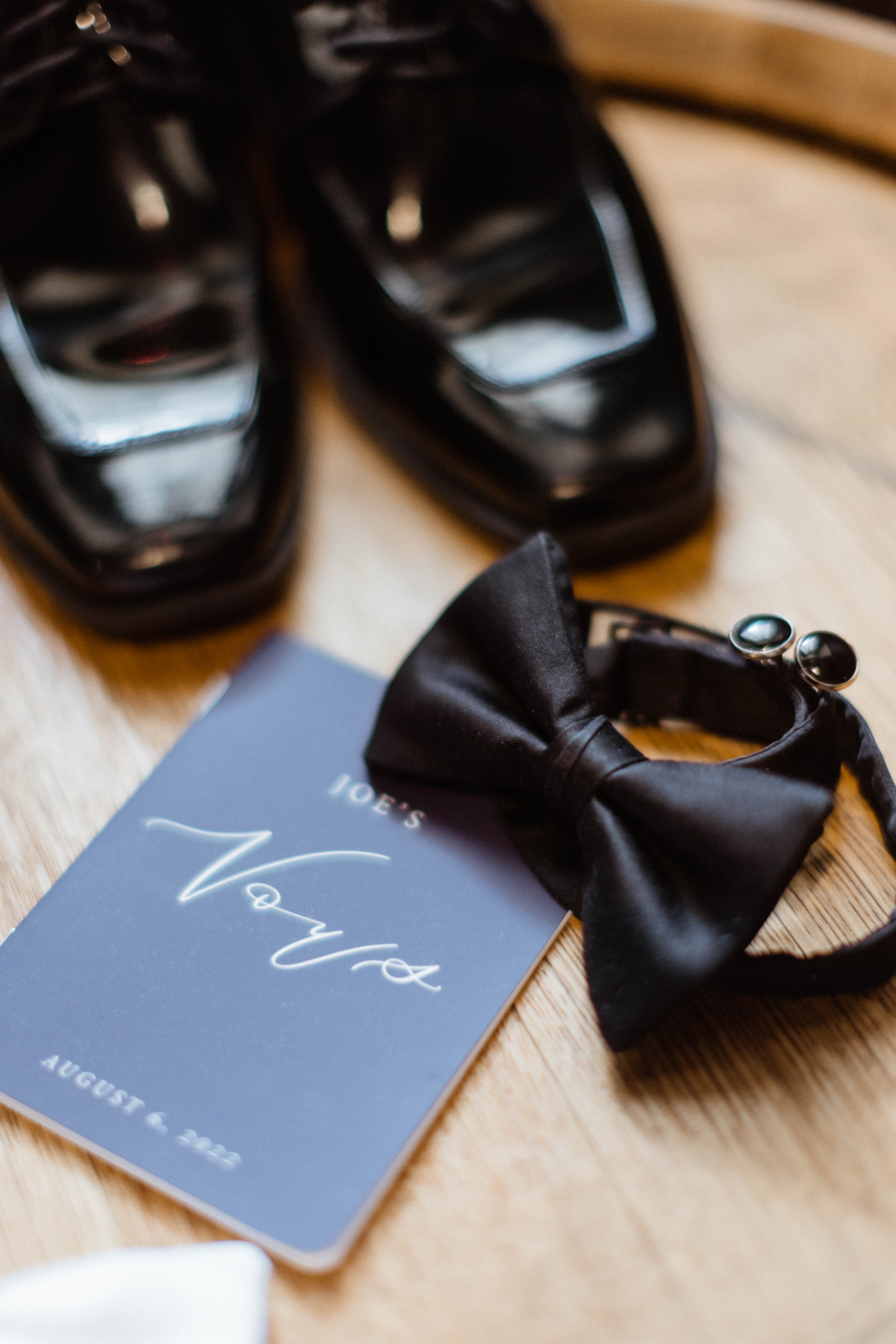 Groom shoes and bowtie lie together before his northeast wedding day