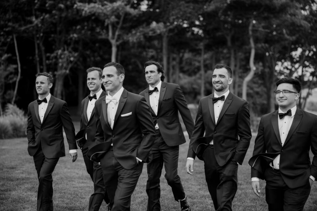 Groom and groomsmen walk together before the dreamy beach wedding