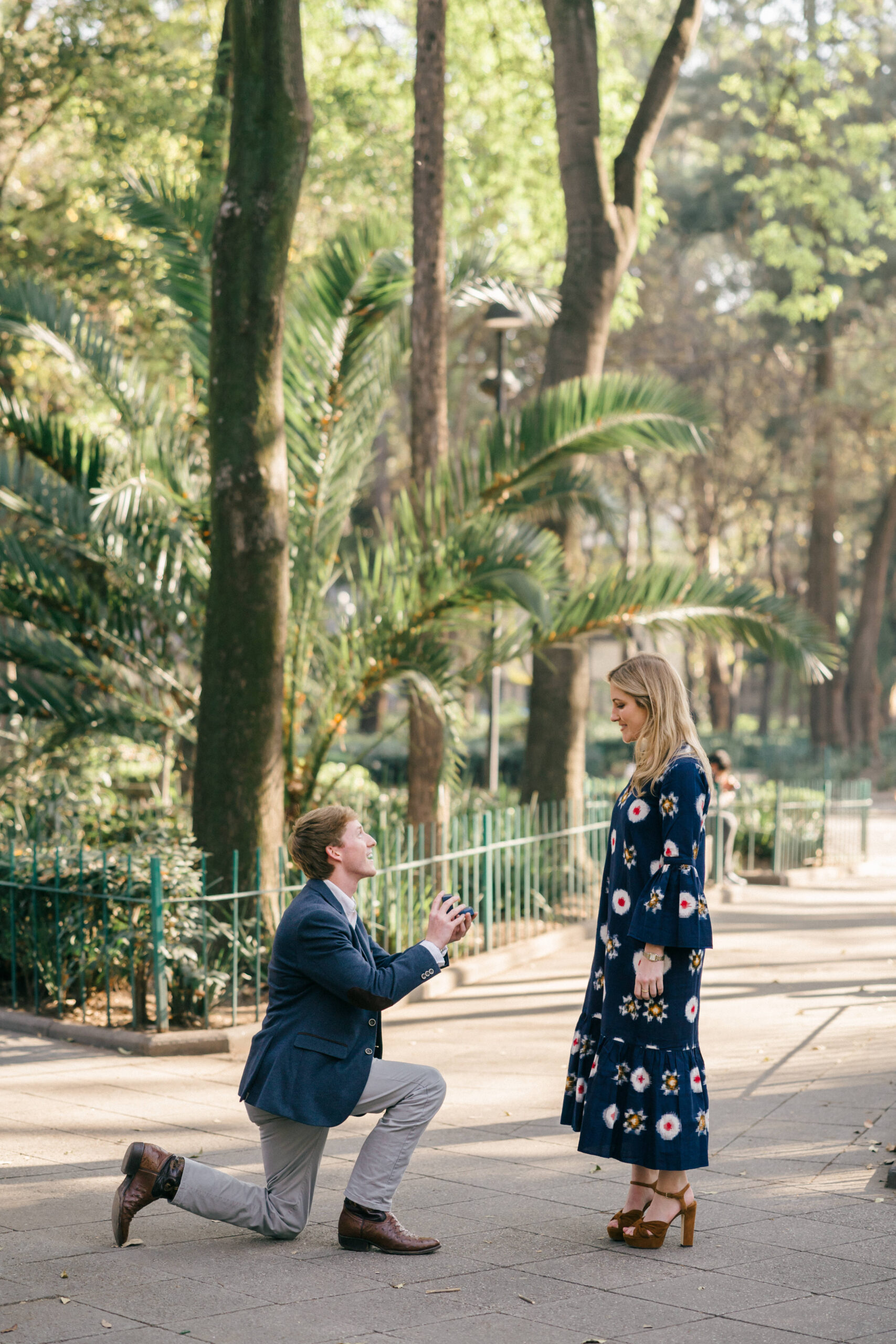 Man on bended knee asking his fiancee for her hand in marriage during their dreamy surprise Mexico city proposal