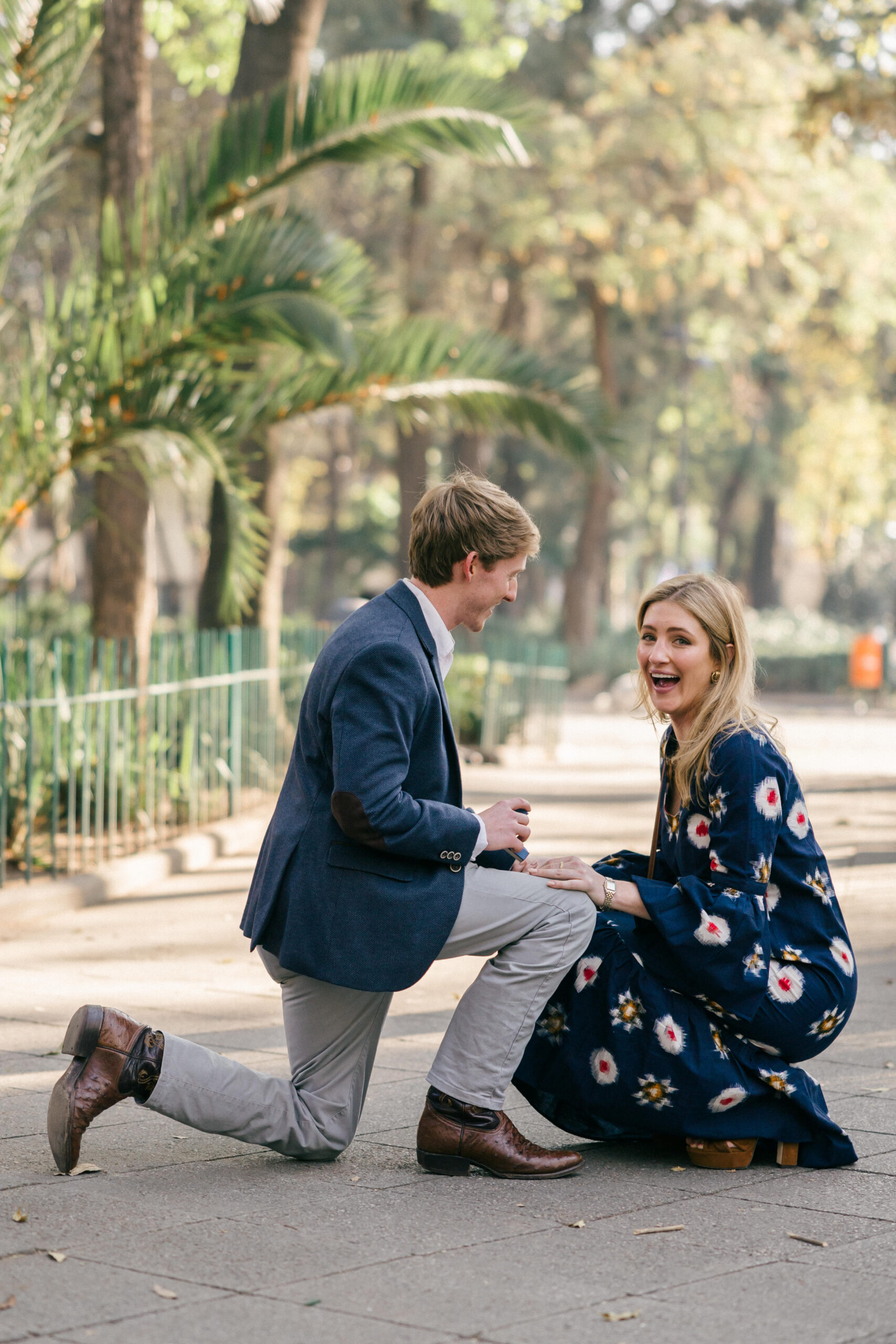Man on bended knee asking his fiancee for her hand in marriage when she realize the photographer is their to capture their dreamy surprise Mexico city proposal