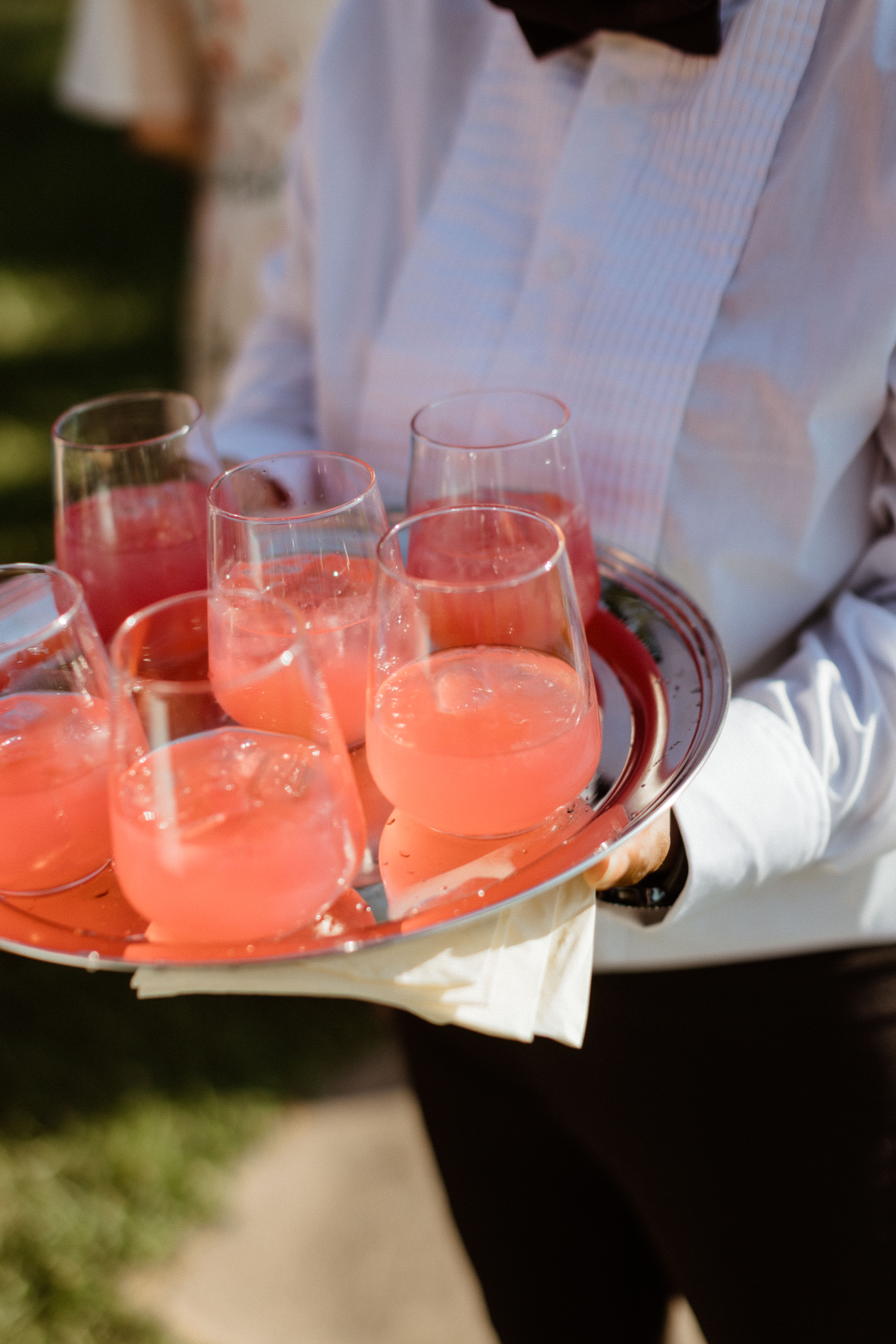 Waiter brings a fresh tray of cocktails out during the cocktail hour