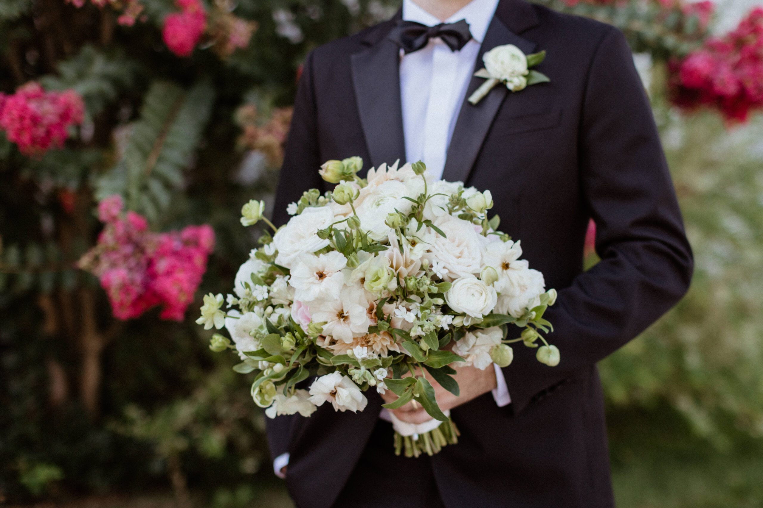 groom carries his brides bouquet after their stunning Bedell Winery wedding day 