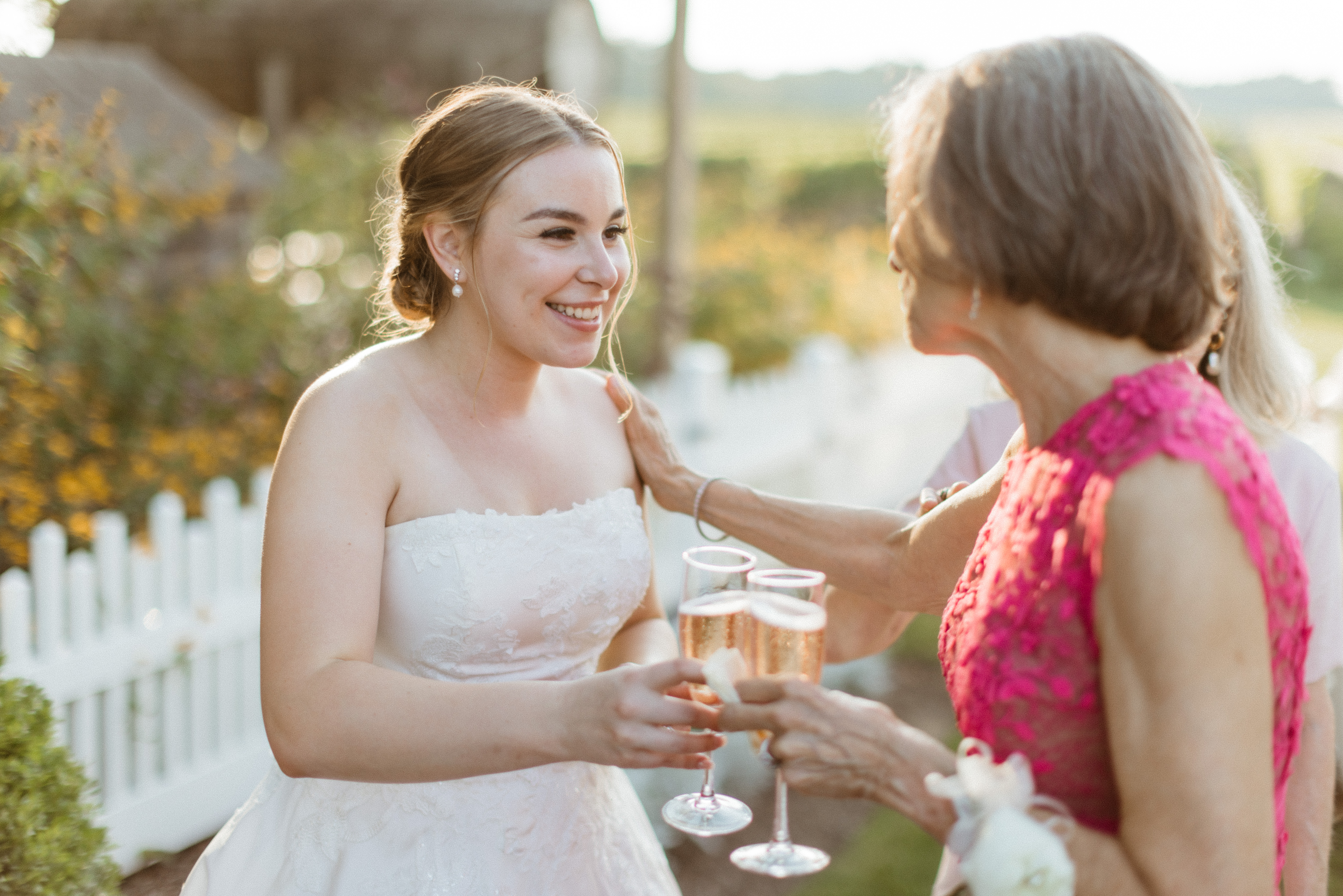 Bride embraces a guest sharing a toast during her stunning Bedell winery wedding reception