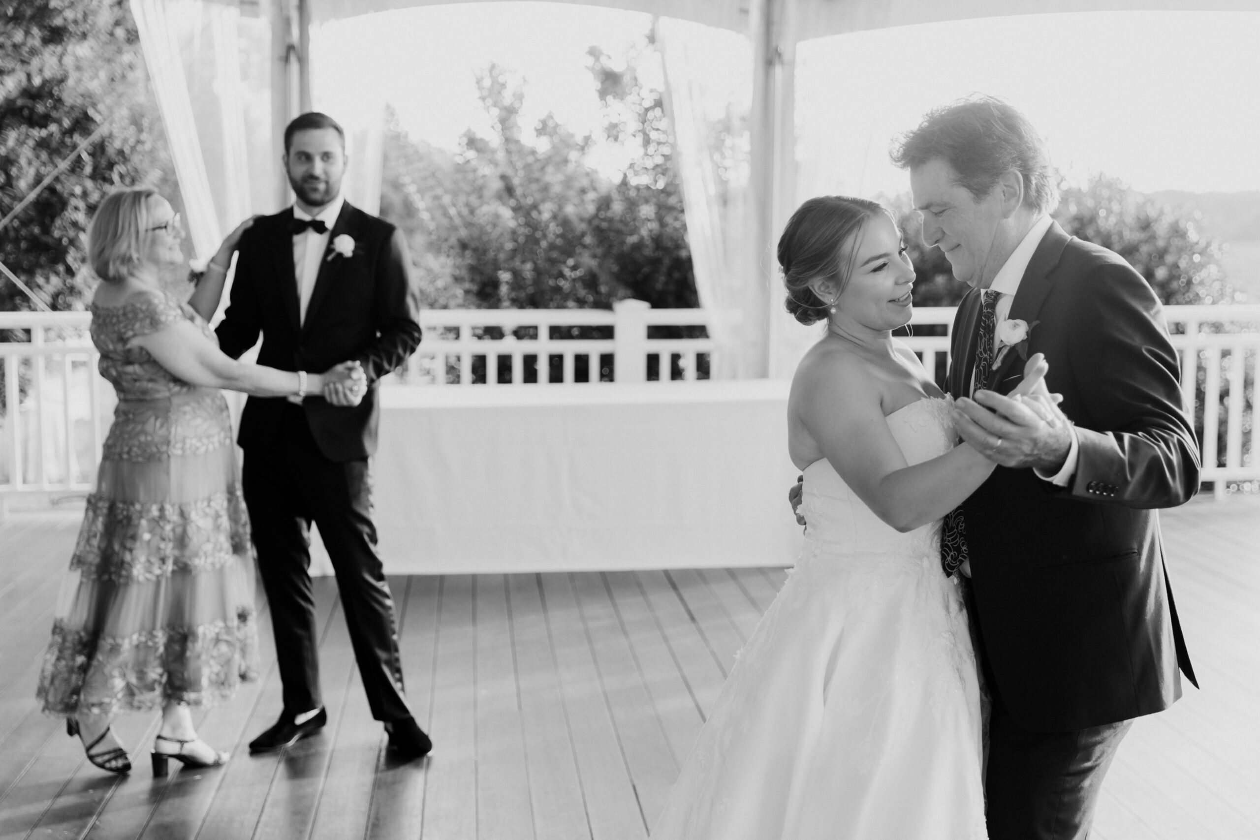 Bride and groom dance with their parents during their stunning wedding reception 