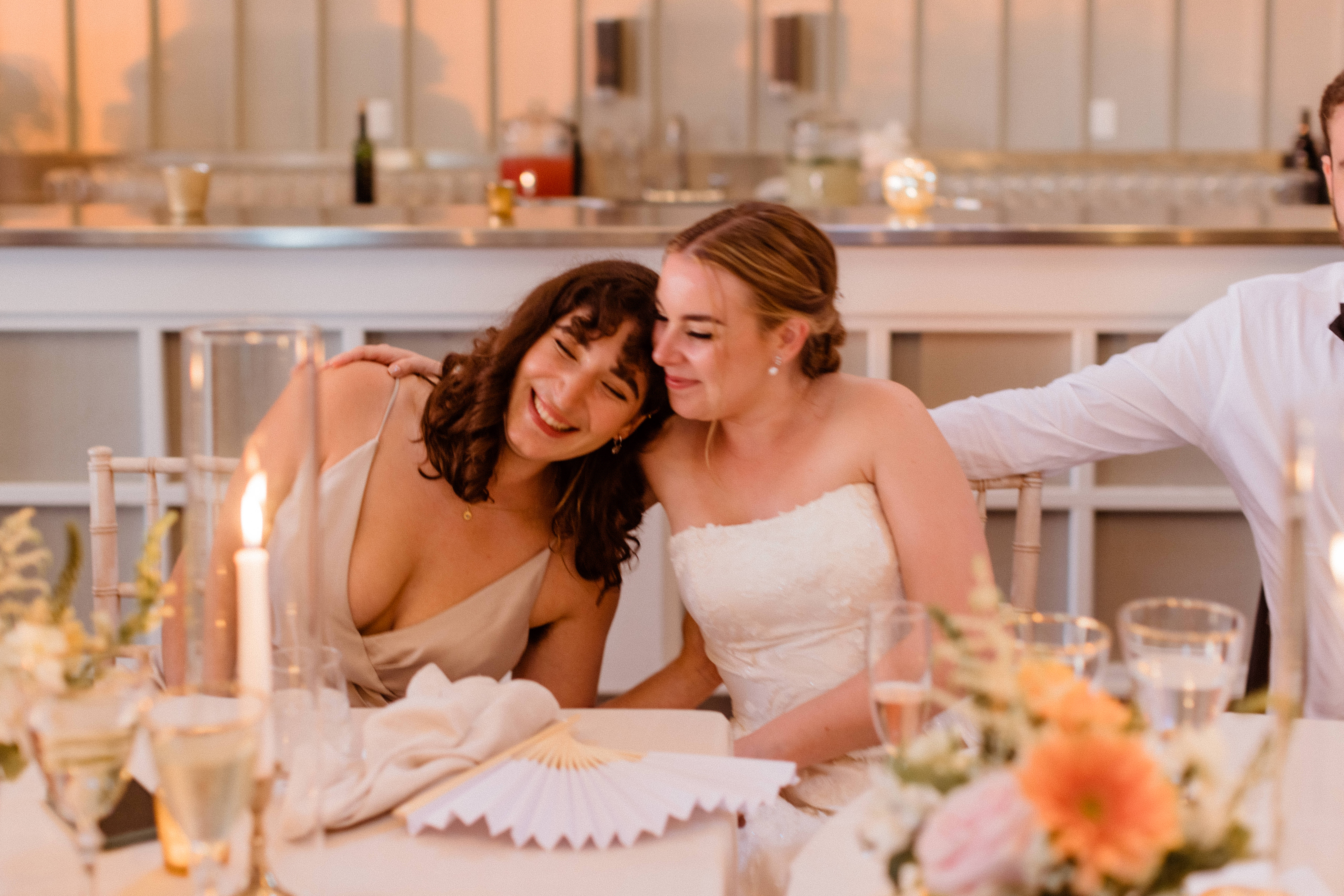 Bride embraces a bridesmaid during the dreamy New York winery wedding reception