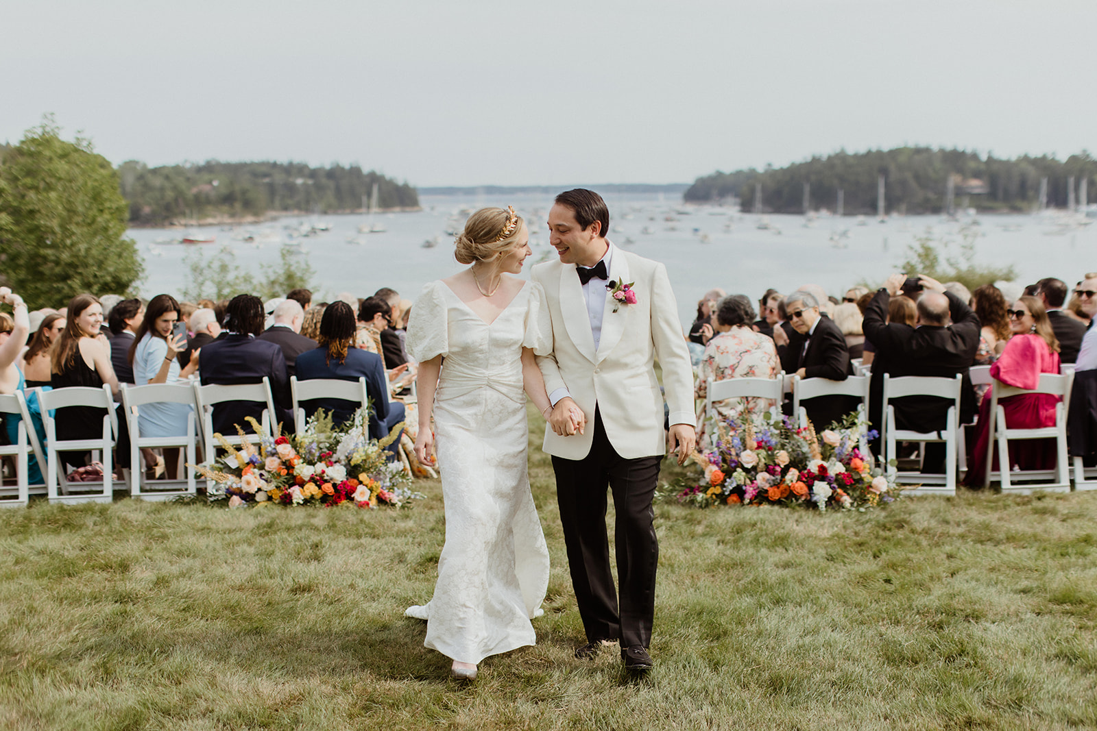 stunning bride and groom share a laugh as they exit stunning Maine wedding